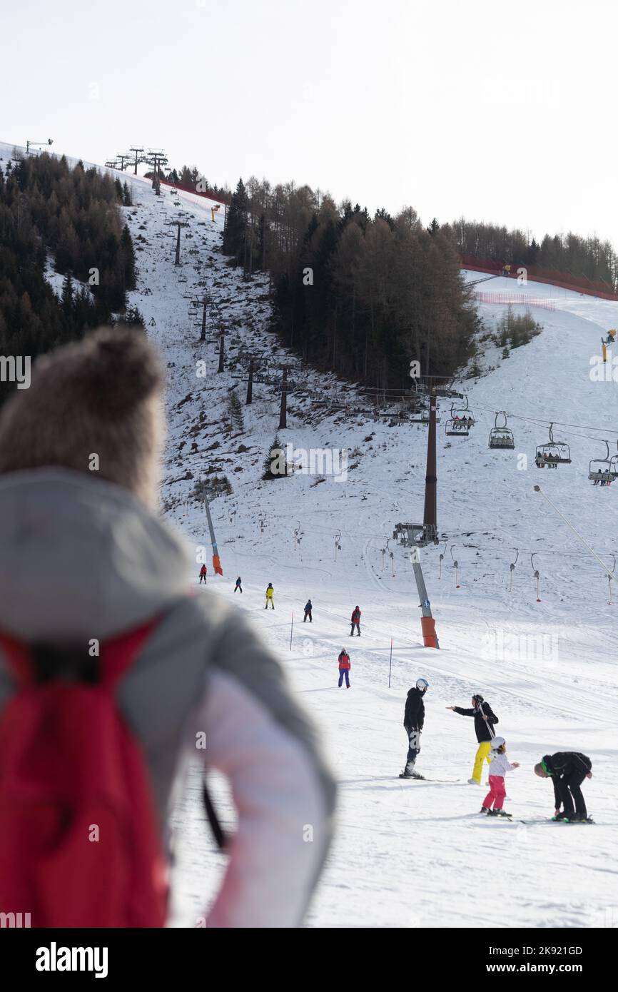 Eine Frau von hinten, die Menschen im Schnee ansieht Stockfoto