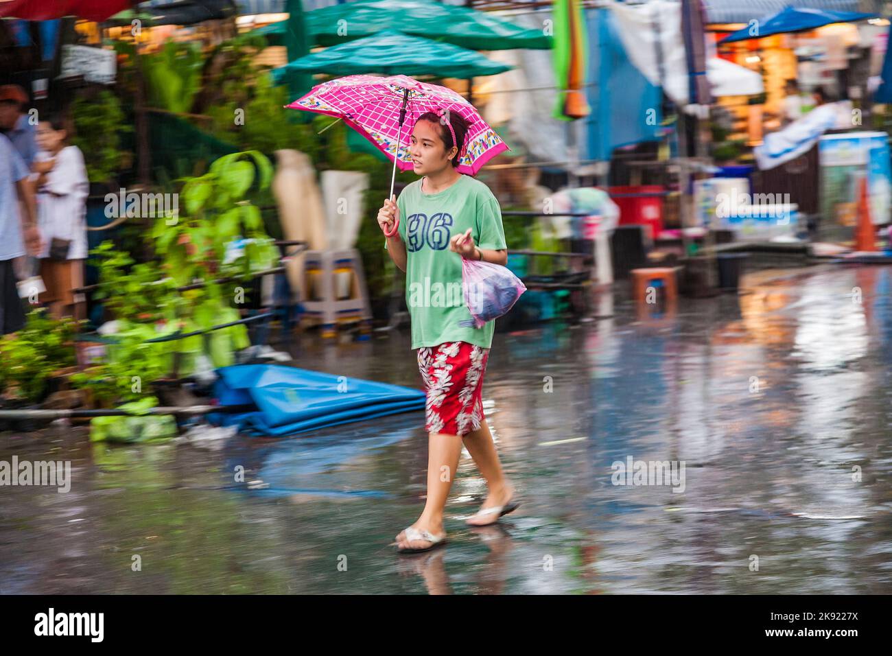 BANGKOK, THAILAND - 10. MAI 2009: Menschen in unscharfer Bewegung auf dem Chatuchak Wochenend-Markt im Regen Bangkok, Thailand. Es ist der größte Markt in Th Stockfoto