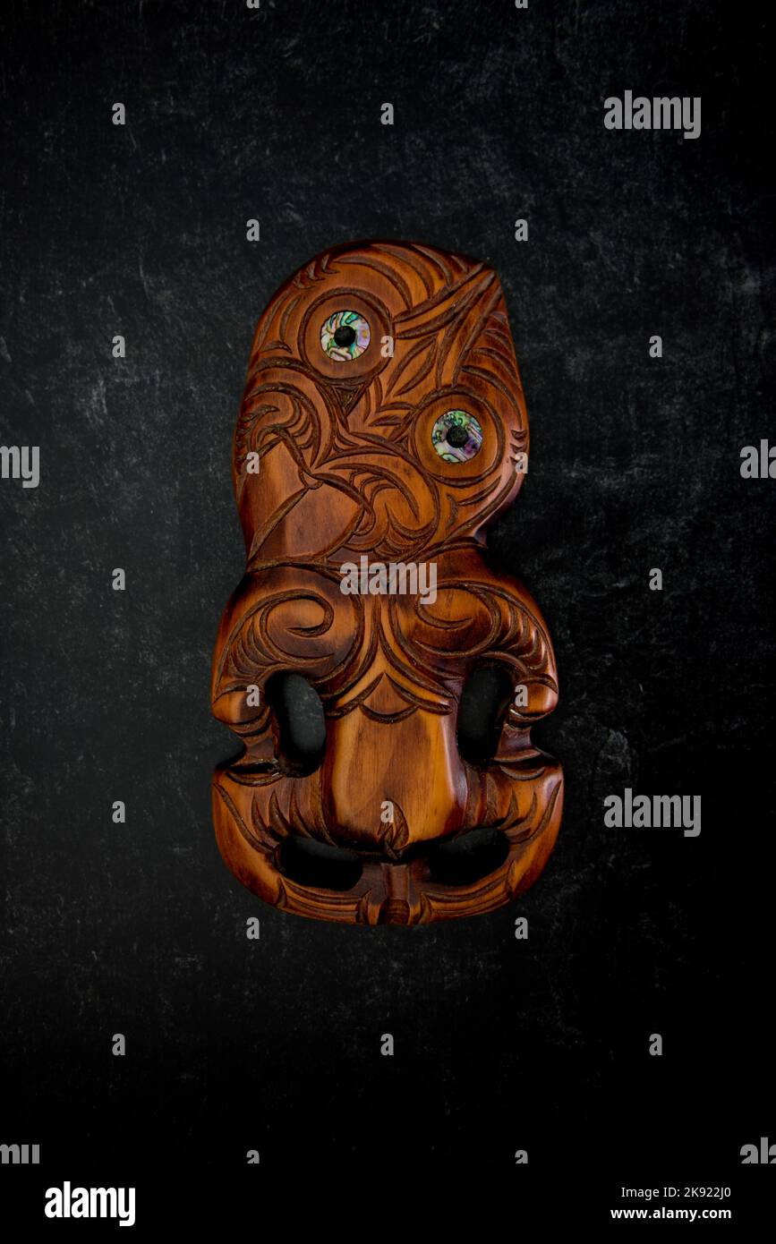 Maori Hei Tiki aus Holz, handgeschnitzt mit Paua-Muschelaugen. Neuseeländische Taonga. Stockfoto