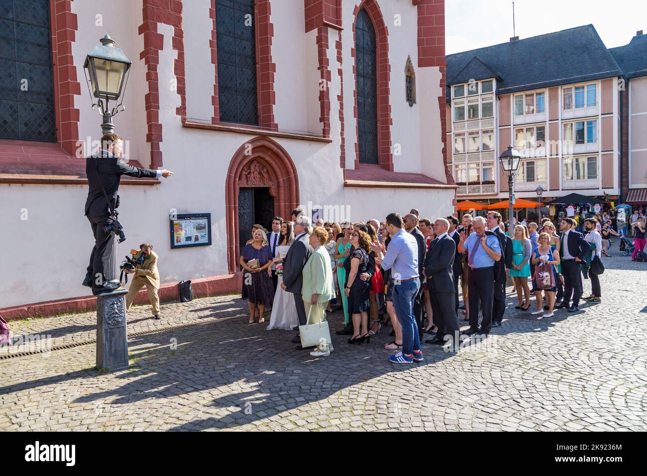 FRANKFURT, DEUTSCHLAND - 9. AUG 2014: Ehepaar mit Familie posiert für ein Hochzeitsfoto vor der Frankfurter Nicolai-Kirche. Stockfoto