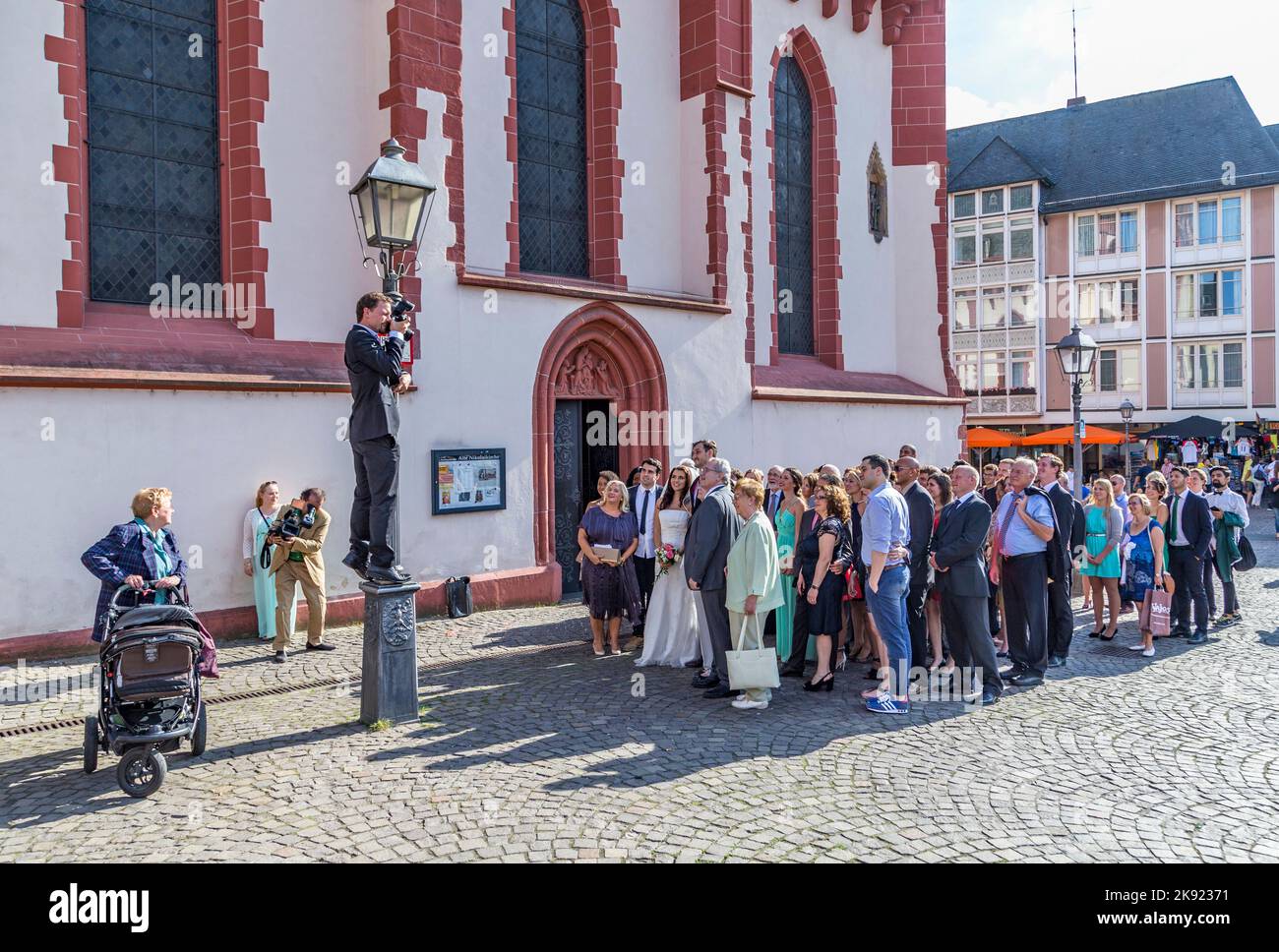 FRANKFURT, DEUTSCHLAND - 9. AUG 2014: Ehepaar mit Familie posiert für ein Hochzeitsfoto vor der Frankfurter Nicolai-Kirche. Stockfoto