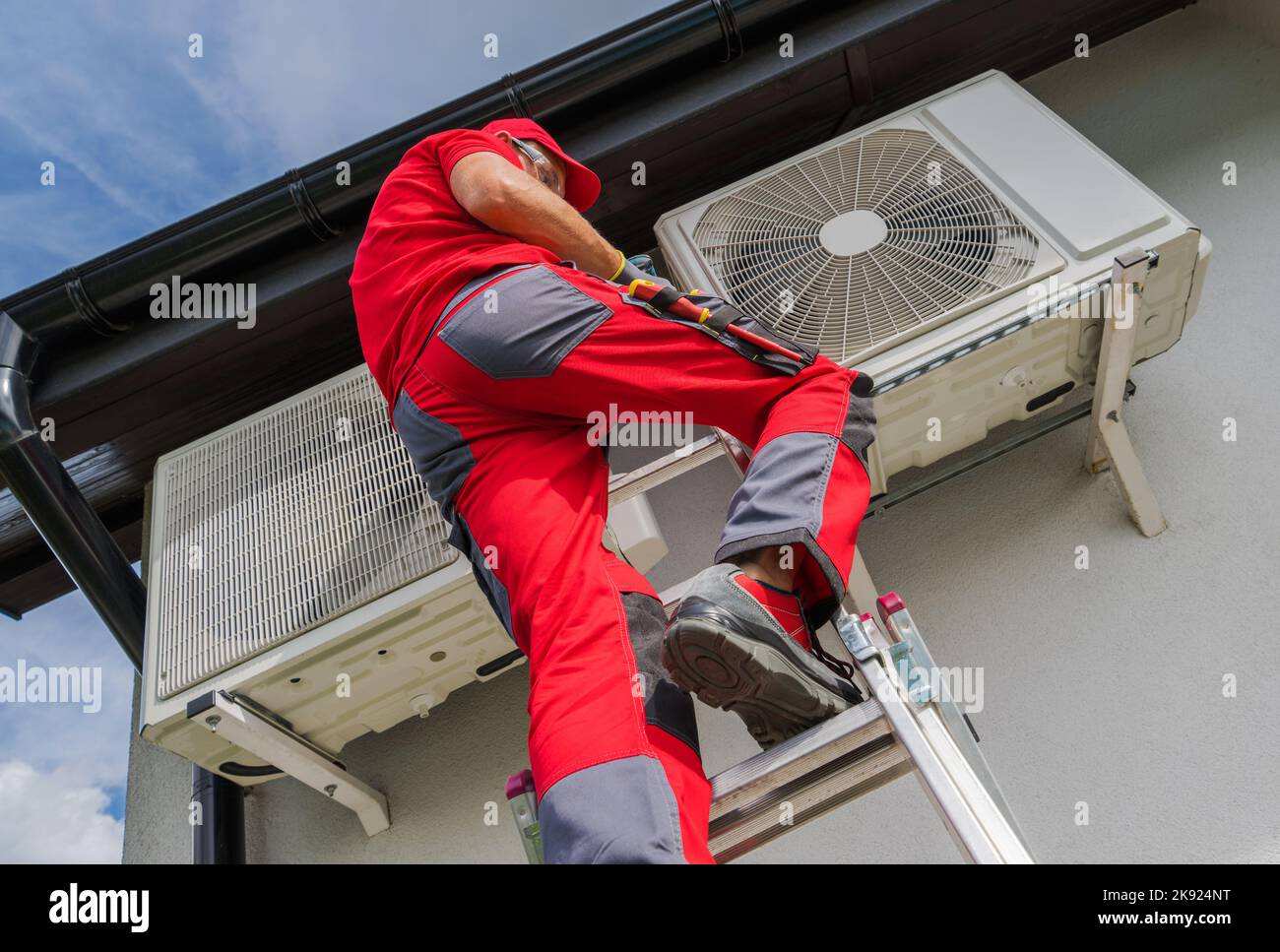 Kaukasischer Professioneller Techniker Überprüft Die Klimaanlage Im Freien Während Der Regelmäßigen Wartungstermin. Installation Der Klimaregelung Für Wohnhäuser Stockfoto