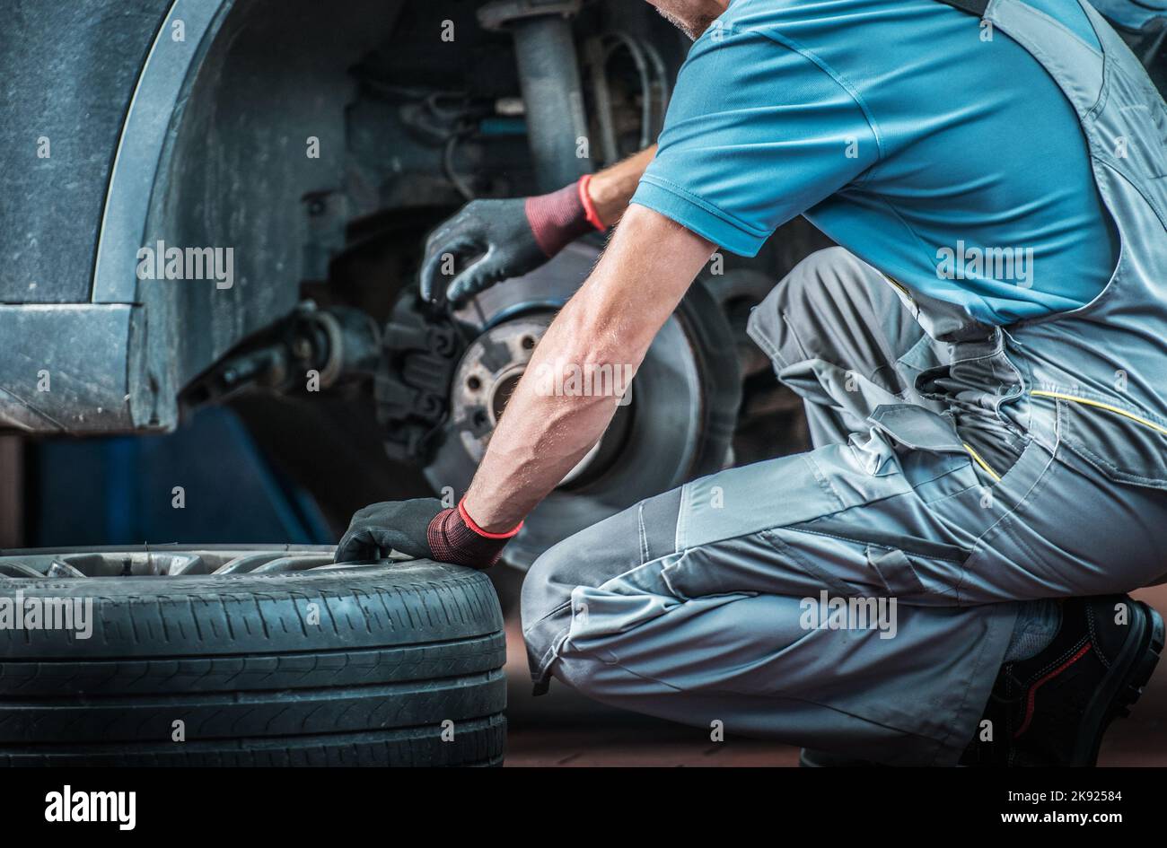 Kaukasischer Mechaniker wechselt bei seinem Auto-Workshop während des geplanten Saisonwechsels die Reifen. Thema Fahrzeugpflege und -Wartung. Stockfoto