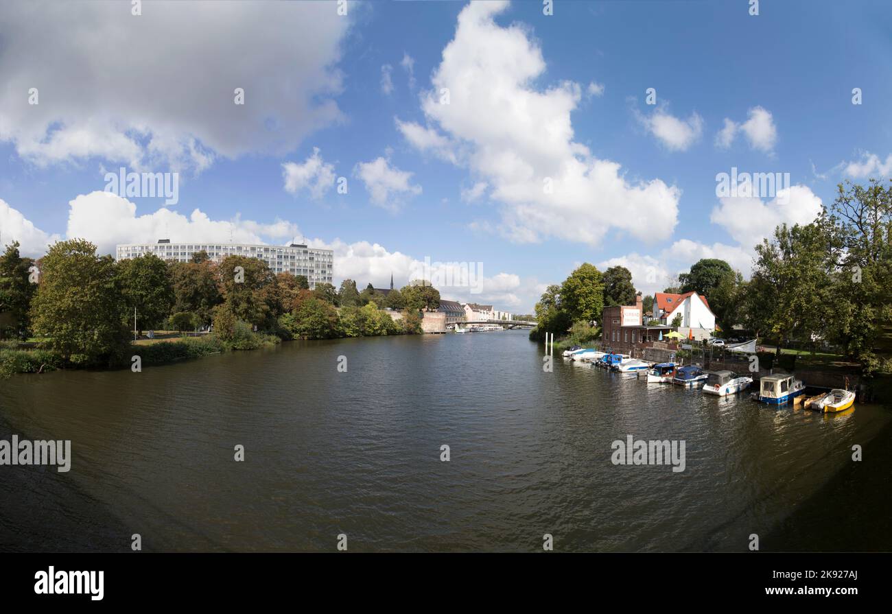 KASSEL, DEUTSCHLAND - SEP 18, 2016: Skyline von Kassel mit Blick auf den Auedamm an der Fulda unter blauem Himmel. Boote parken am Museum Pier Jungborn. Stockfoto