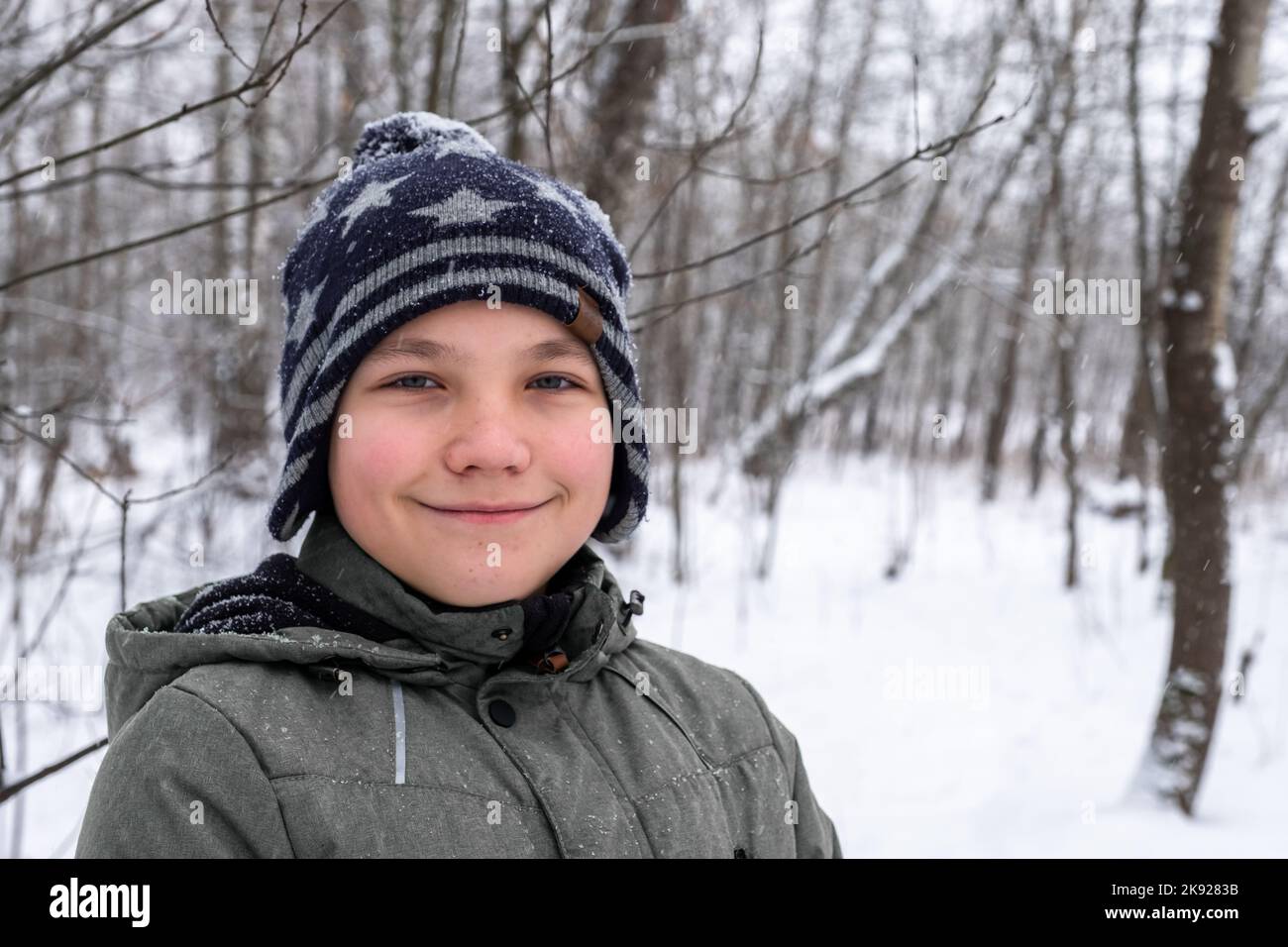 Porträt eines Jungen auf dem Hintergrund eines Winterwaldes Stockfoto