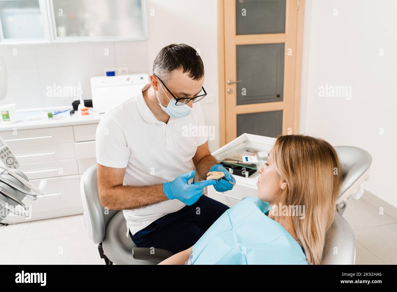 Günstiger Zahnarzt In Der Nähe Zahnarzt, der Zahnabguss der Patientin vor der Implantation zeigt