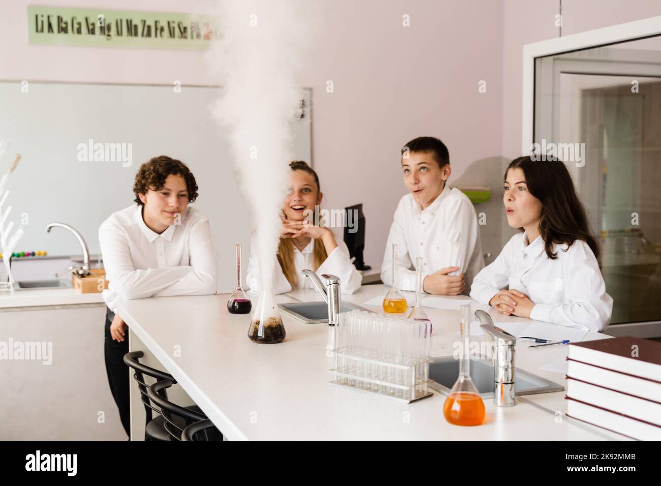 Vulkanexperiment. Die Chemielehrerin der Schule zeigt den Kindern Experimente im Labor. Bildungskonzept. Gruppenunterricht von Klassenkameraden in Chemie Stockfoto