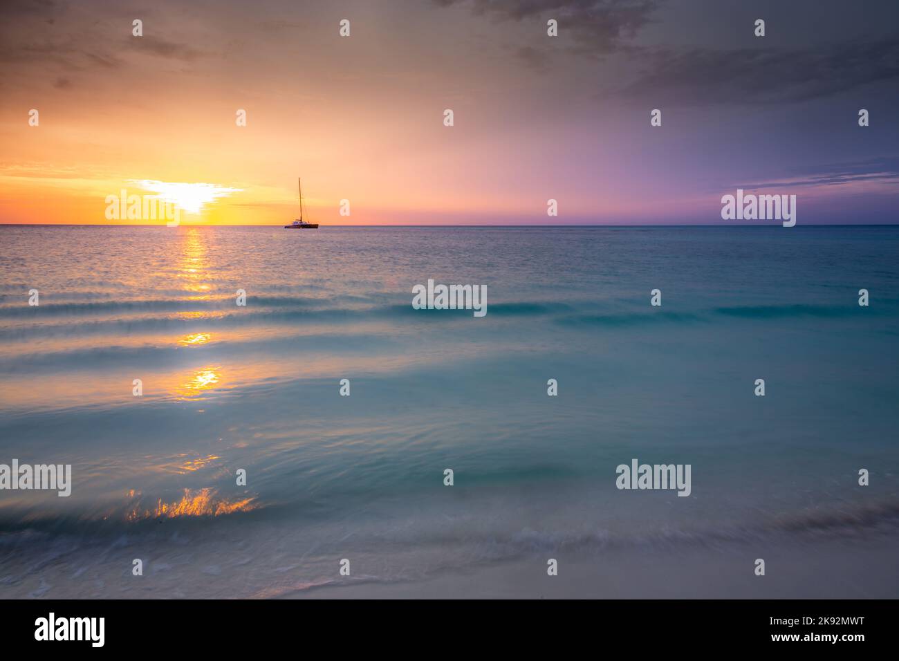 Aruba idyllischer karibischer Strand mit Booten bei Sonnenuntergang, Niederländisches Antillen Meer Stockfoto