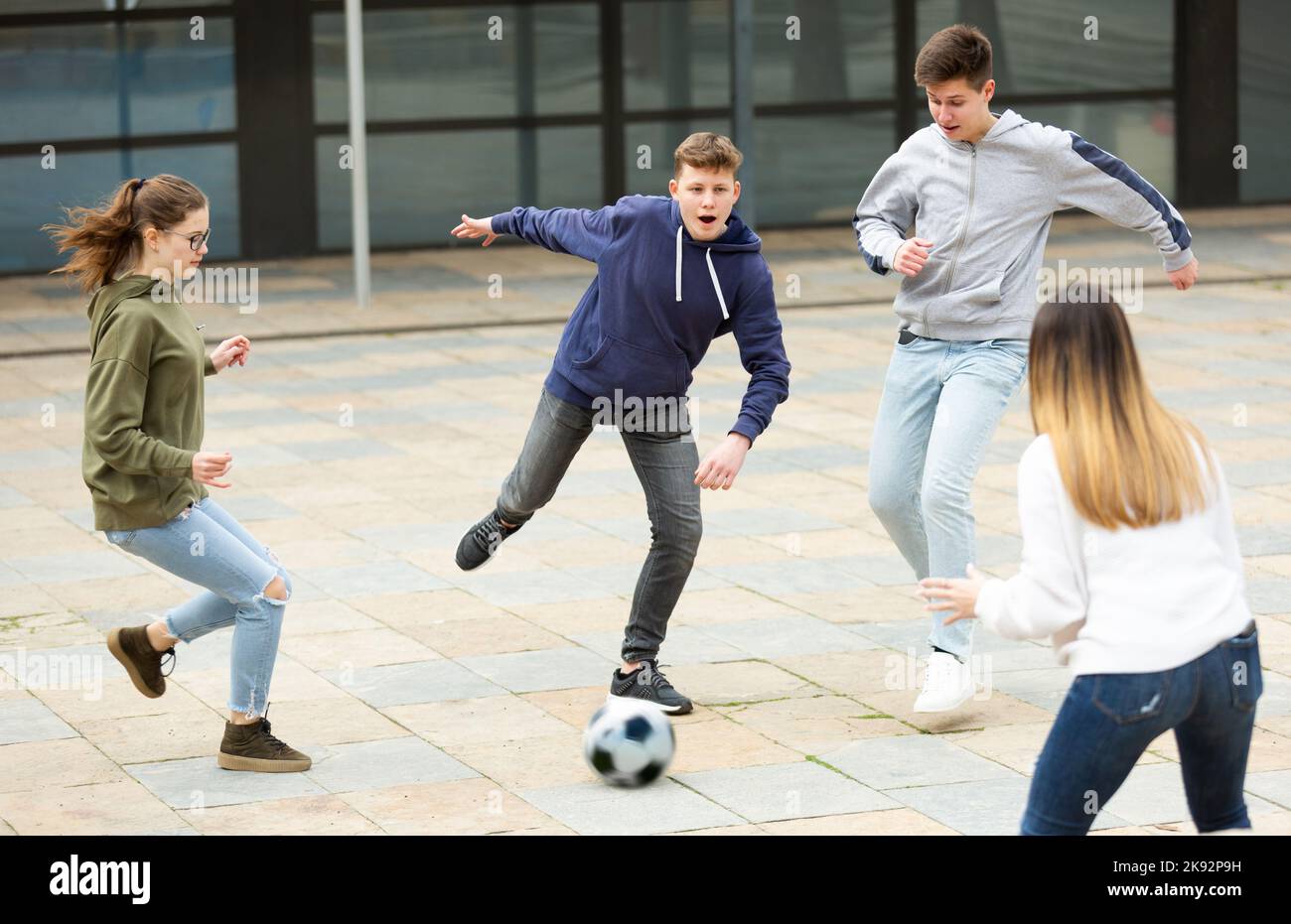 Jugendliche spielen Fußball mit Ball draußen Stockfoto