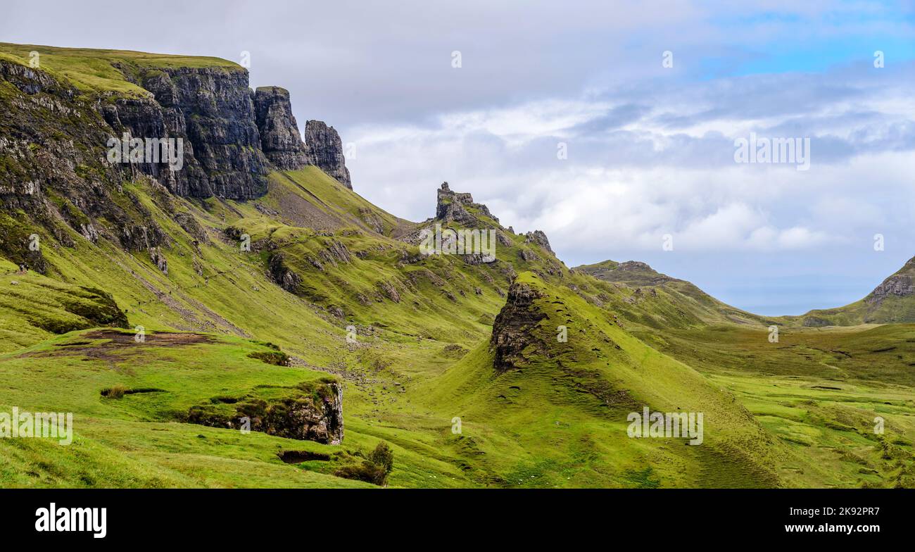 Wunderschöne, dramatische schottische Berglandschaft, spitze, zerklüftete Berggipfel und schiere Felswände, entlang der Quiraing Hills Walk, grünes Gras und shr Stockfoto