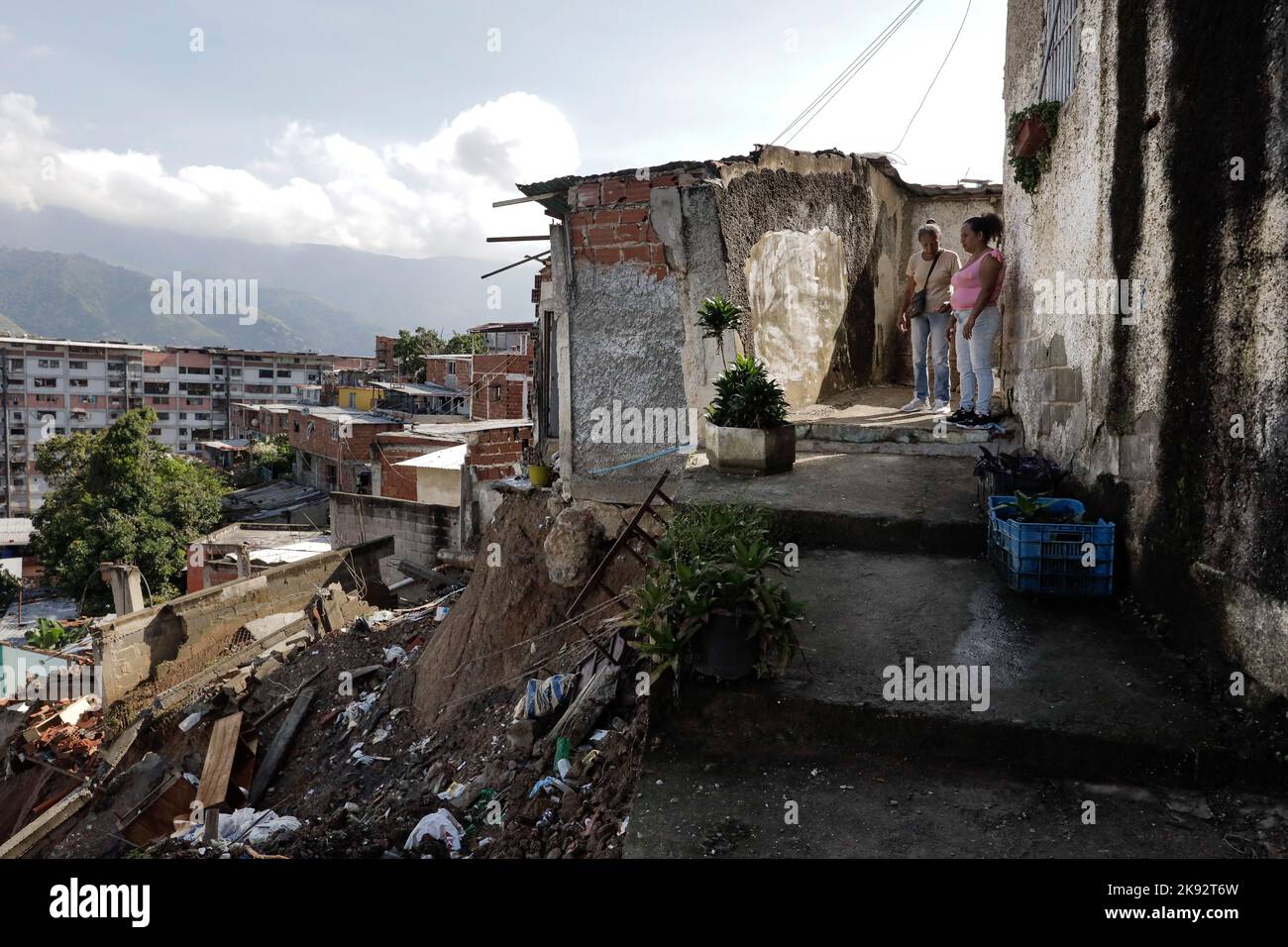 Caracas, Venezuela. 25. Oktober 2022. Zwei Frauen schauen sich die Überreste ihres Hauses an, das durch einen Erdrutsch nach heftigen Regenfällen, von denen Dutzende Häuser im Viertel 23 de Enero betroffen waren, verwüstet wurde. Kredit: Jesus Vargas/dpa/Alamy Live Nachrichten Stockfoto