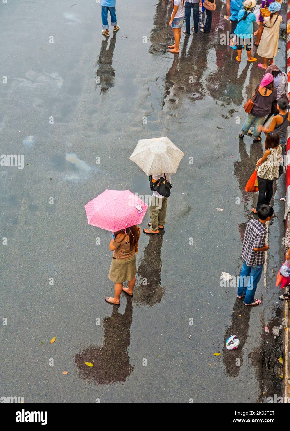 BANGKOK, THAILAND - 10. MAI 2009: Die Menschen warten auf den Bus am Chatuchak Wochenend-Markt bei Regen in Bangkok, Thailand. Im Mai ist die Monsunzeit mit Stockfoto