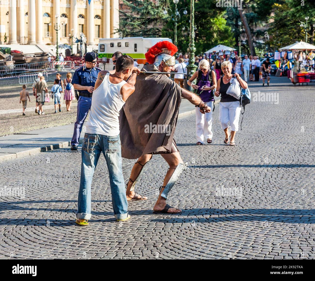 VERONA, ITALIEN - 5. AUG 2009: Menschen am Platz im römischen Amphitheater von Verona, Italien. Ein Schauspieler bietet seine Dienste als Erinnerungsfoto an Stockfoto