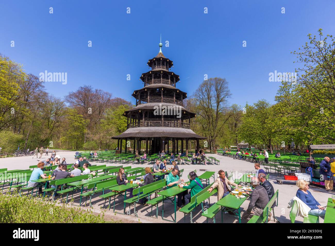 MÜNCHEN, DEUTSCHLAND - APR 20, 2015: Die Menschen genießen den Biergarten in der Nähe des chinesischen Turms im englischen Garten in München, Bayern, Deutschland. Stockfoto