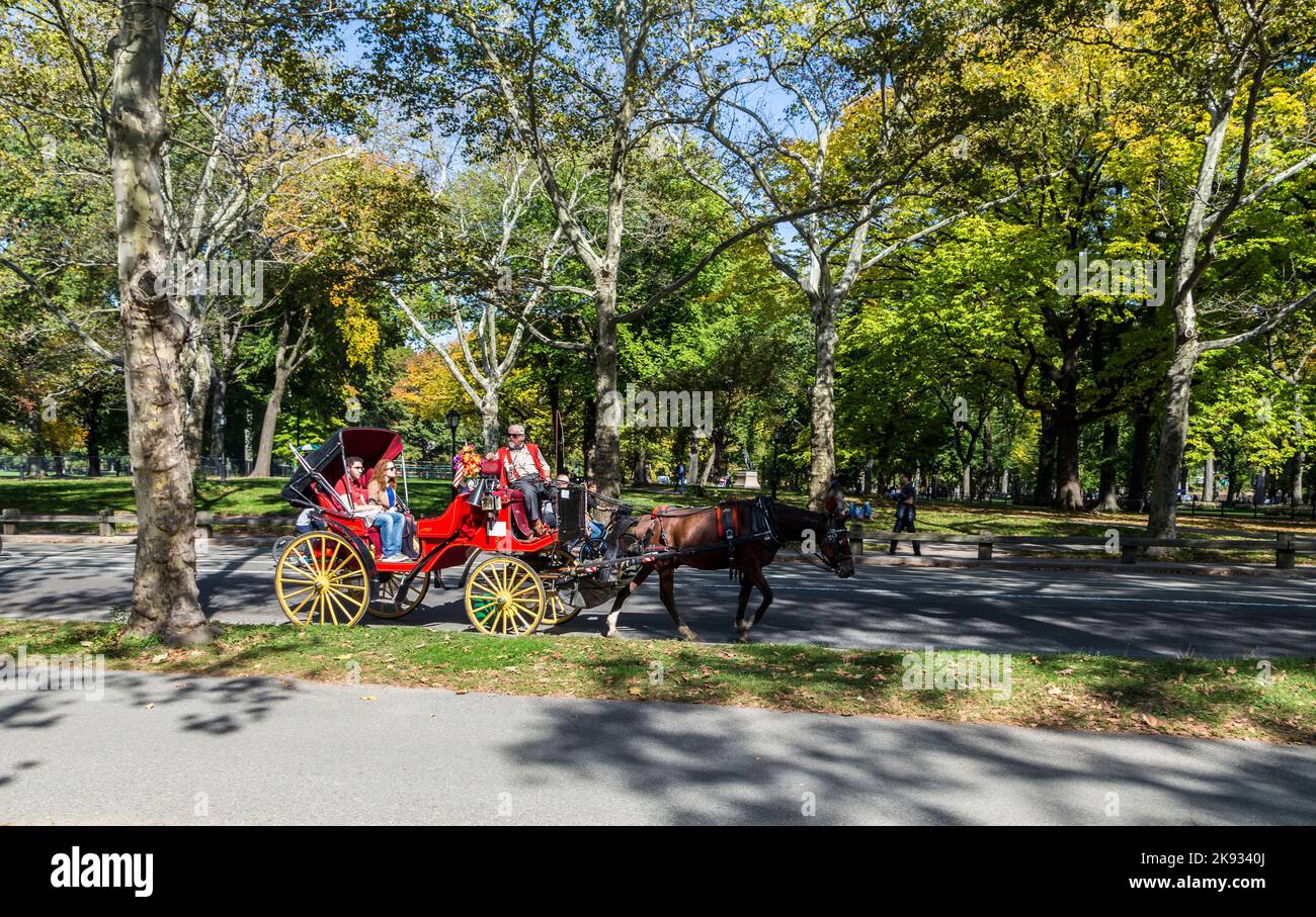 NEW YORK, USA - 21. Okt 2015: Die Menschen genießen die Kutschenfahrt im Central Park in Manhattan. Pferdekutschen sind eine wunderbare Möglichkeit, das Be zu erleben Stockfoto