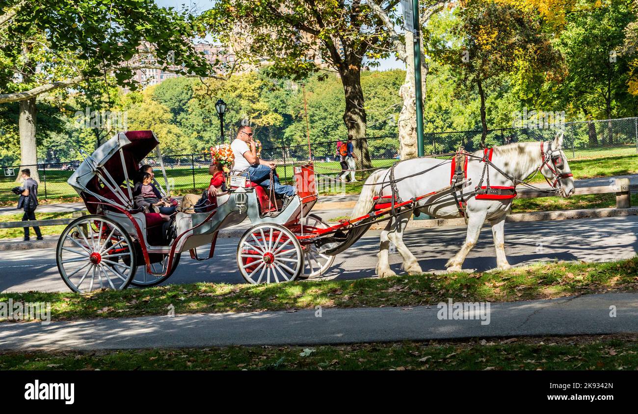 NEW YORK, USA - 21. Okt 2015: Die Menschen genießen die Kutschenfahrt im Central Park in Manhattan. Pferdekutschen sind eine wunderbare Möglichkeit, das Be zu erleben Stockfoto