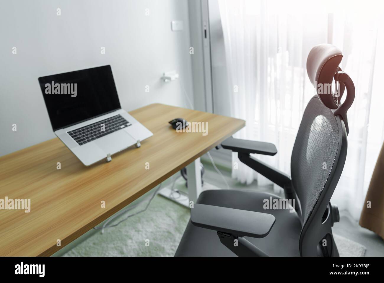 Ergonomischer Stuhl und verstellbarer Tisch mit Laptop-Computer am modernen Arbeitsplatz. Gute Haltung, um das Office-Syndrom, Rückenschmerzen, Schulterschmerzen, Fibrom zu vermeiden Stockfoto