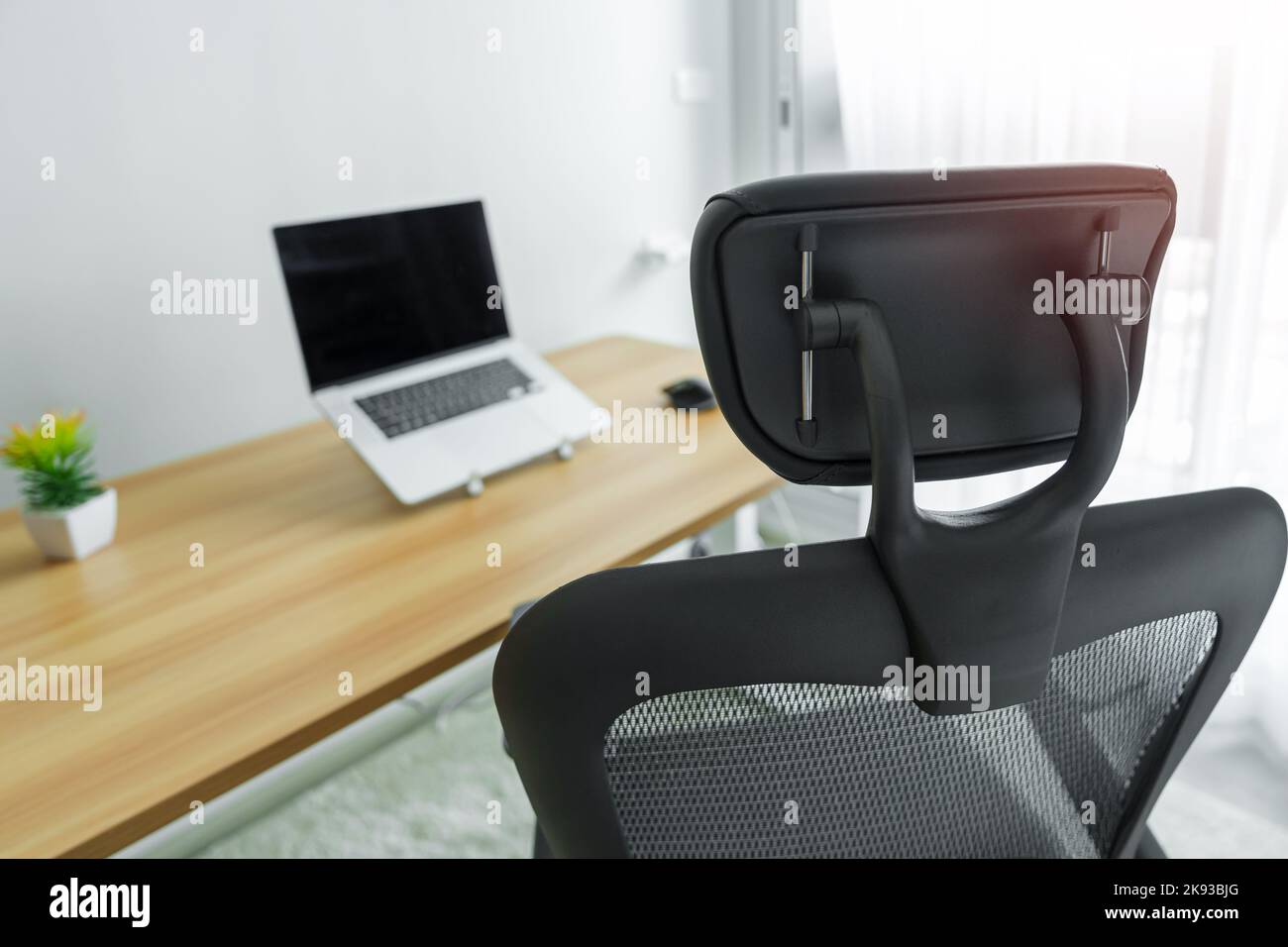 Ergonomischer Stuhl und verstellbarer Tisch mit Laptop-Computer am modernen Arbeitsplatz. Gute Haltung, um das Office-Syndrom, Rückenschmerzen, Schulterschmerzen, Fibrom zu vermeiden Stockfoto