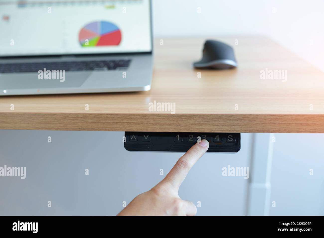 Handverstellung ergonomischer elektrischer Schreibtisch oder höhenverstellbarer Tisch bei langer Arbeit für eine gute Körperhaltung, um Office-Syndrom, Rückenschmerzen zu vermeiden, sollte Stockfoto