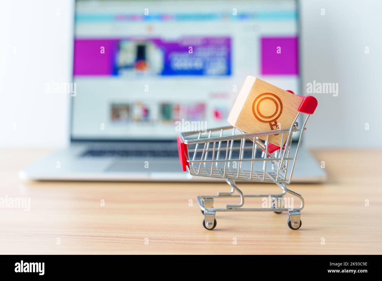 Warenkorb mit Vergrößerungsymbolblock und Laptop-Computer mit Marktplatz-Website, Technologie, E-Commerce, SEO, Suchmaschinenoptimierung, Adverti Stockfoto