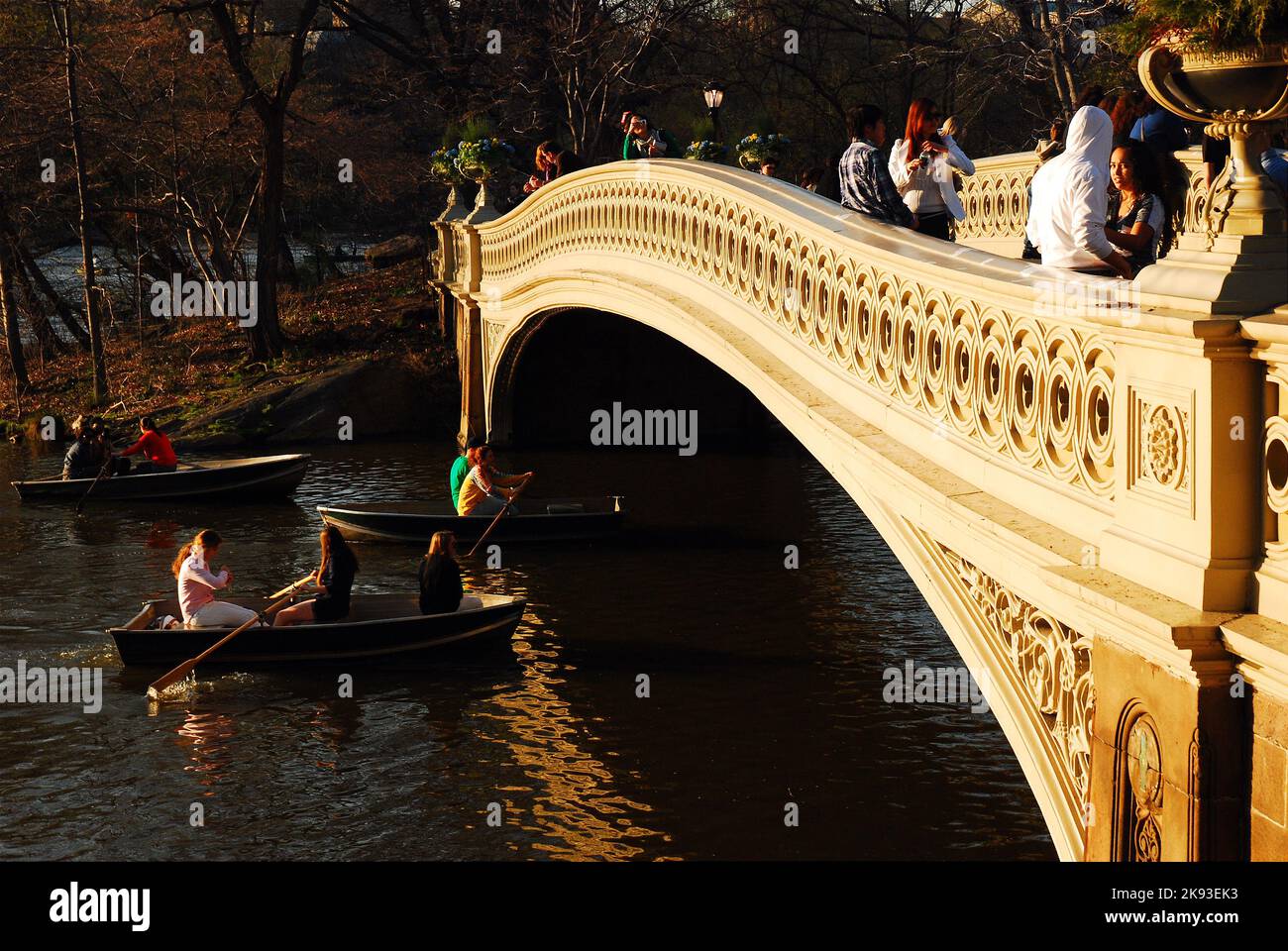 Die Menschen genießen einen schönen und warmen Frühlingstag, rudern auf dem See oder gehen einfach über die Bow Bridge im New York City Central Park Stockfoto