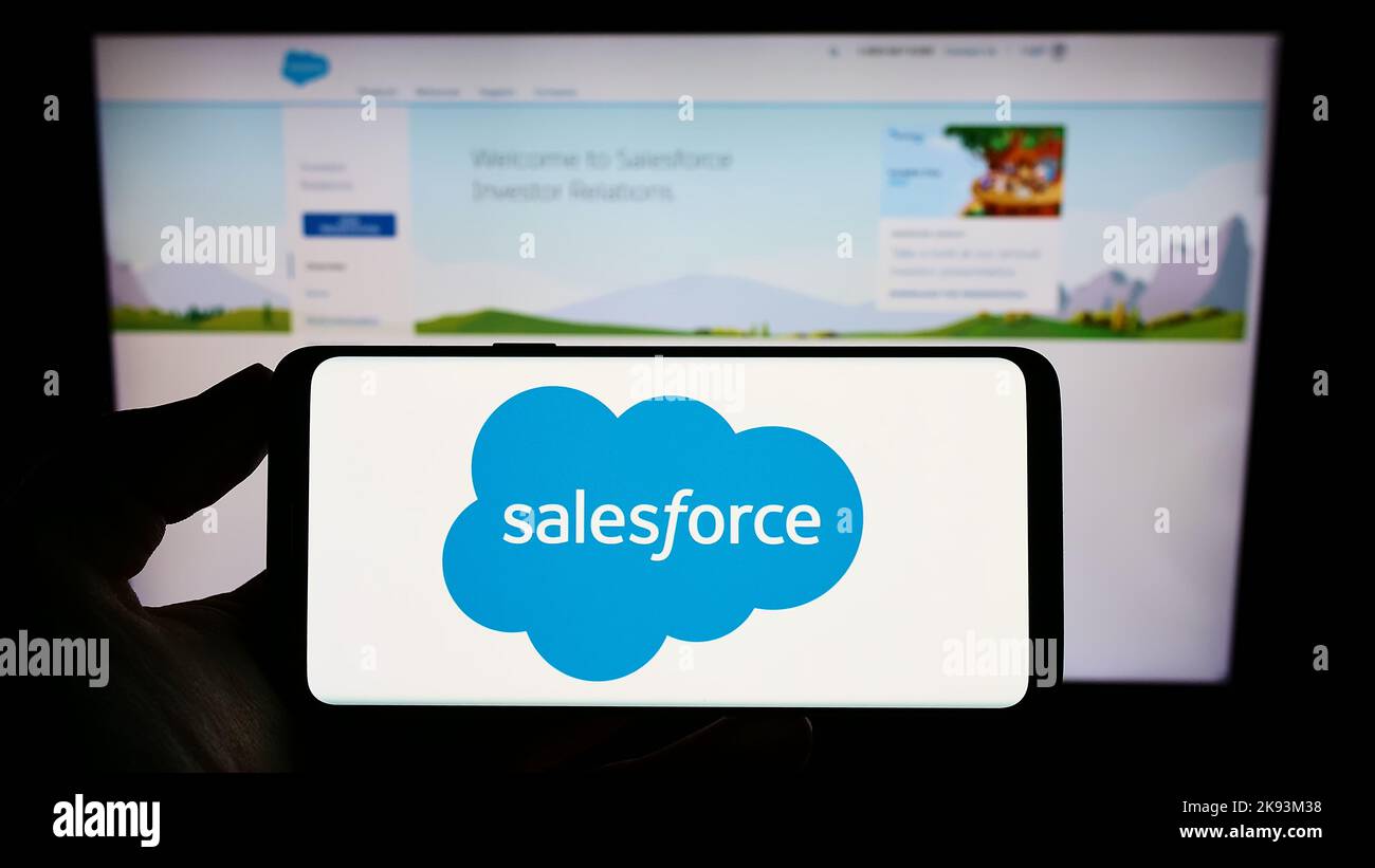 Person, die Mobiltelefon mit dem Logo des US-amerikanischen Softwareunternehmens Salesforce Inc. Auf dem Bildschirm vor der Business-Webseite hält. Konzentrieren Sie sich auf die Telefonanzeige. Stockfoto