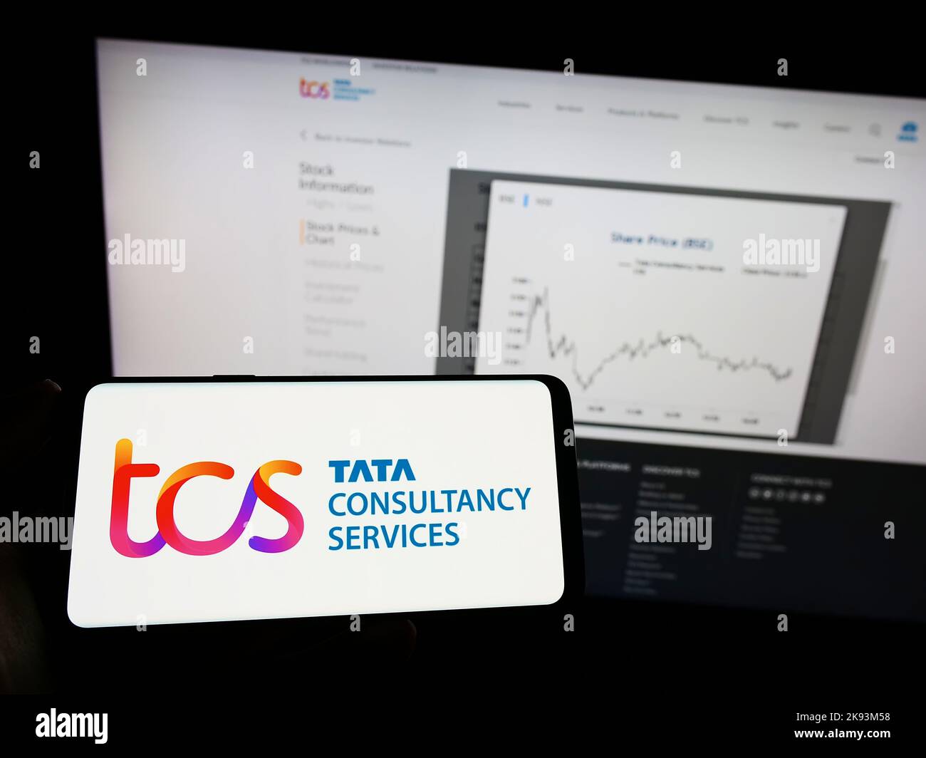 Person, die das Mobiltelefon mit dem Logo des indischen Unternehmens Tata Consultancy Services (TCS) auf dem Bildschirm vor der Webseite hält. Konzentrieren Sie sich auf die Telefonanzeige. Stockfoto
