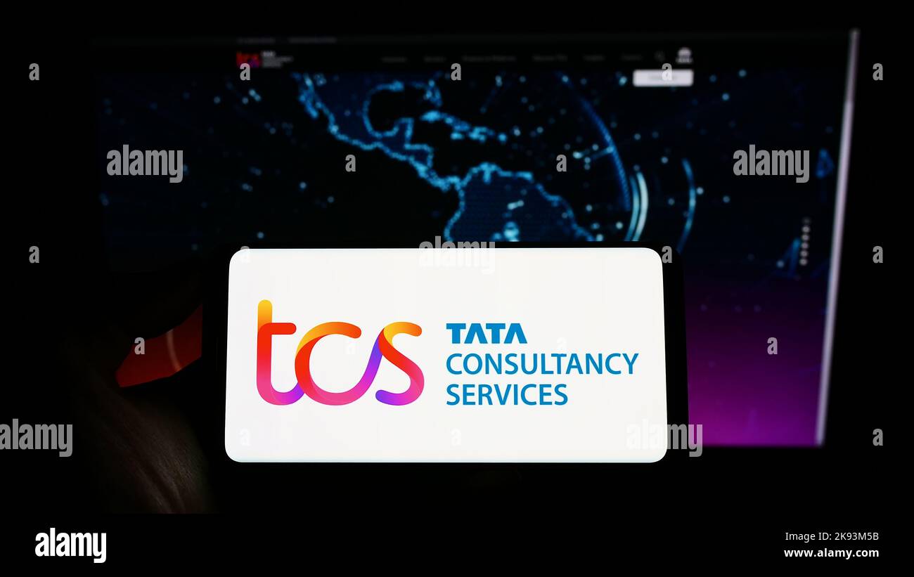 Person, die das Smartphone mit dem Logo des indischen Unternehmens Tata Consultancy Services (TCS) auf dem Bildschirm vor der Website hält. Konzentrieren Sie sich auf die Telefonanzeige. Stockfoto