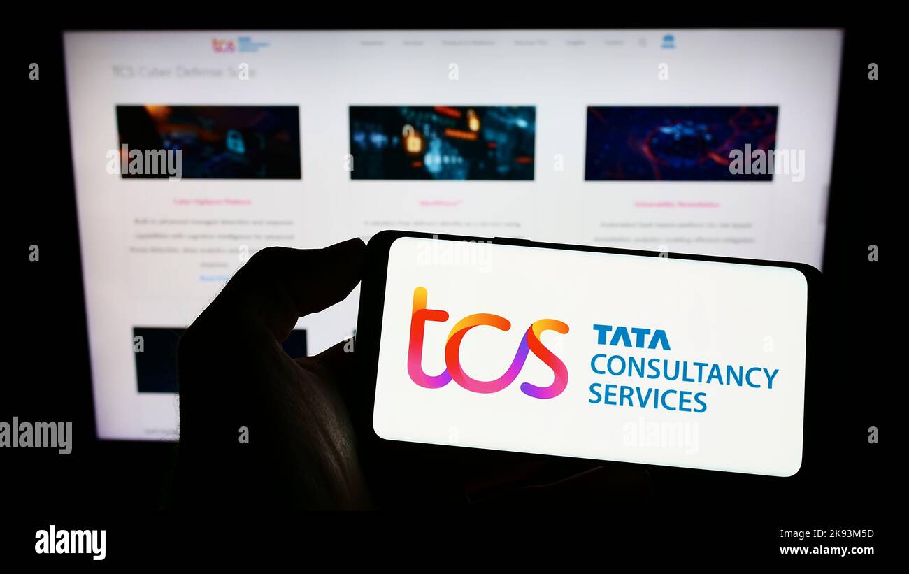Person, die Mobiltelefon mit dem Logo des indischen Unternehmens Tata Consultancy Services (TCS) auf dem Bildschirm vor der Webseite hält. Konzentrieren Sie sich auf die Telefonanzeige. Stockfoto