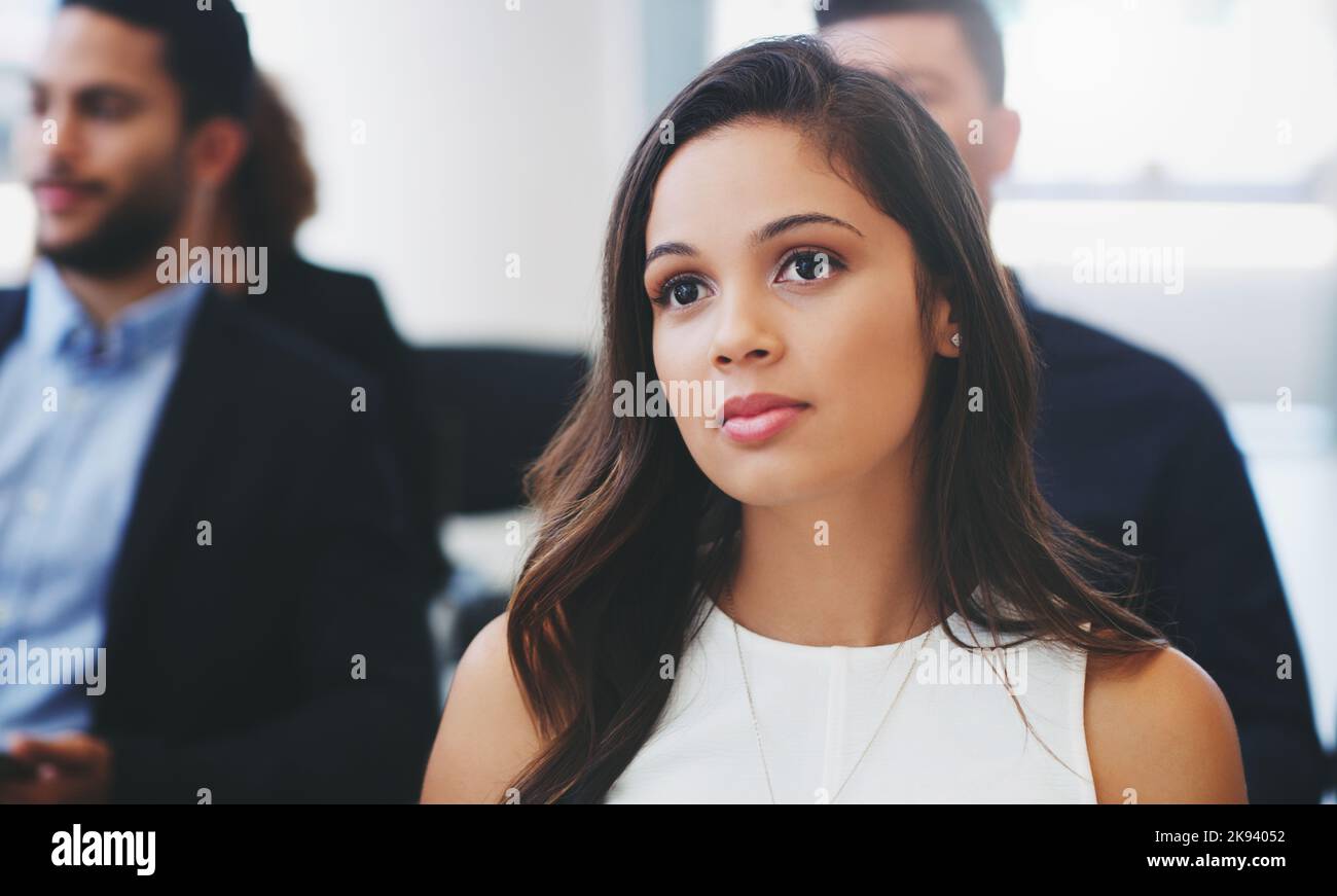 Eine junge Geschäftsfrau, die im Publikum einer Geschäftskonferenz sitzt. Stockfoto