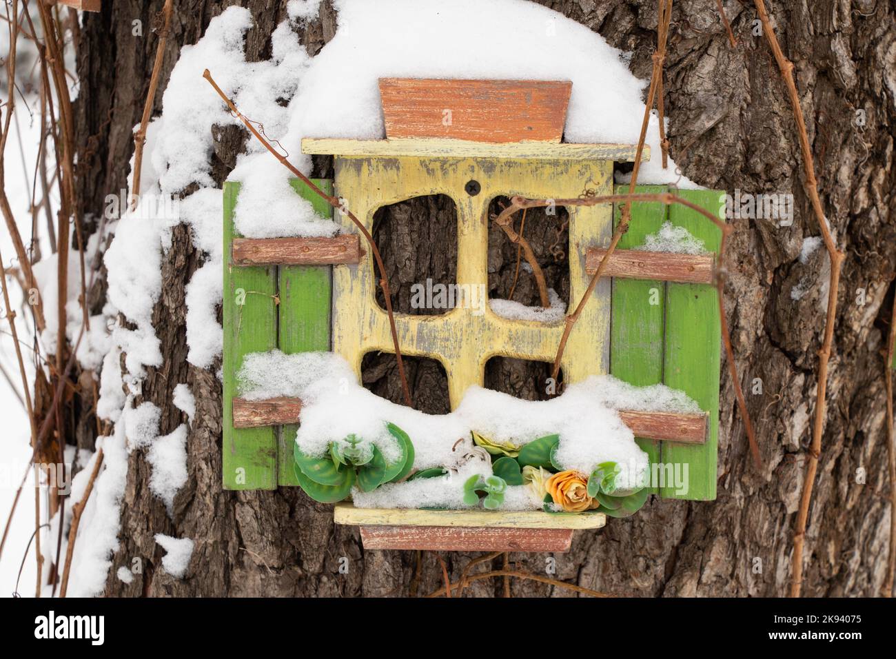 Kleines märchenhaftes Holzhaus in einem Baum in einem Park im Winter im Schnee Stockfoto