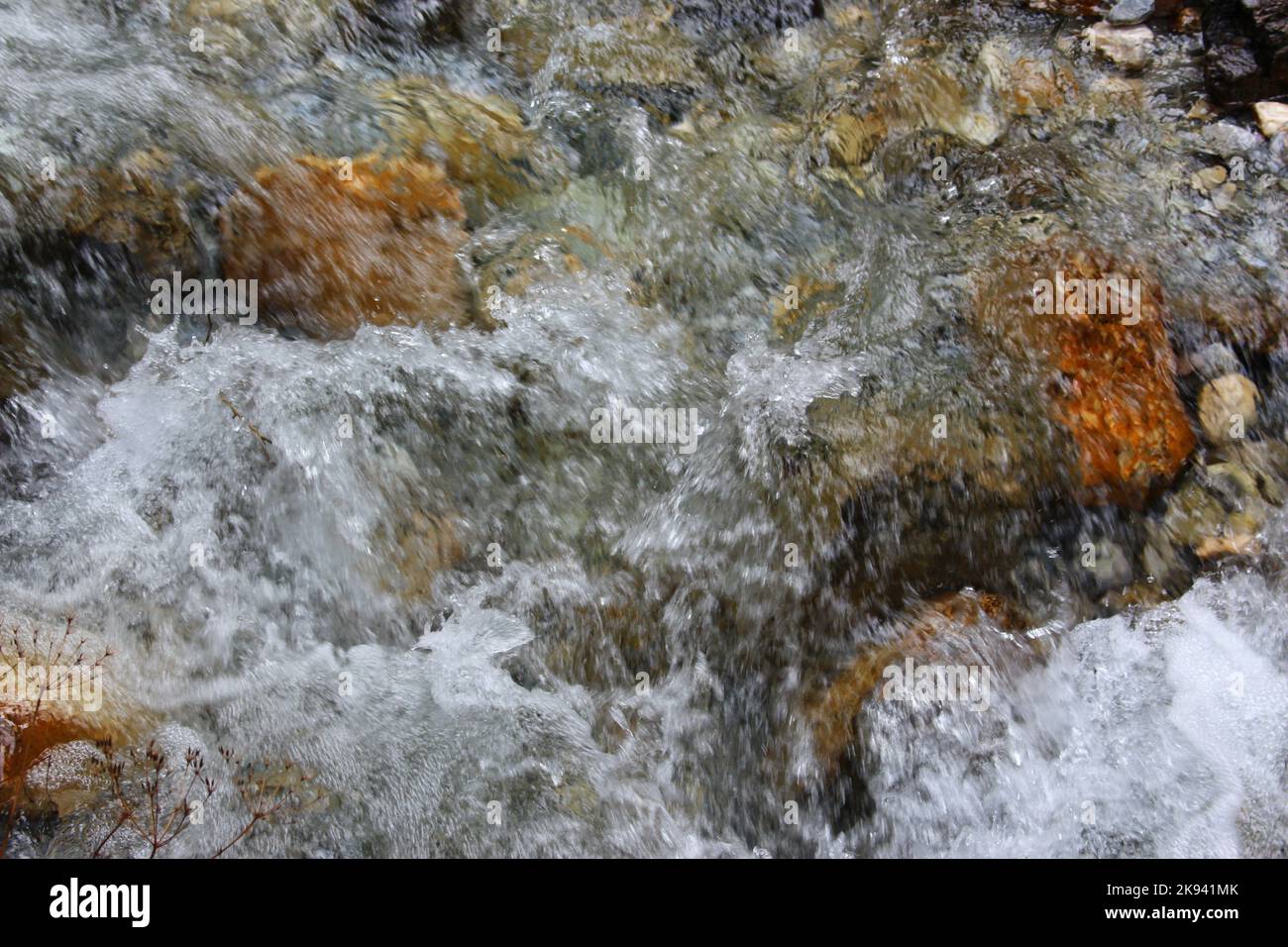 Wasser glitzert um Steine herum Stockfoto