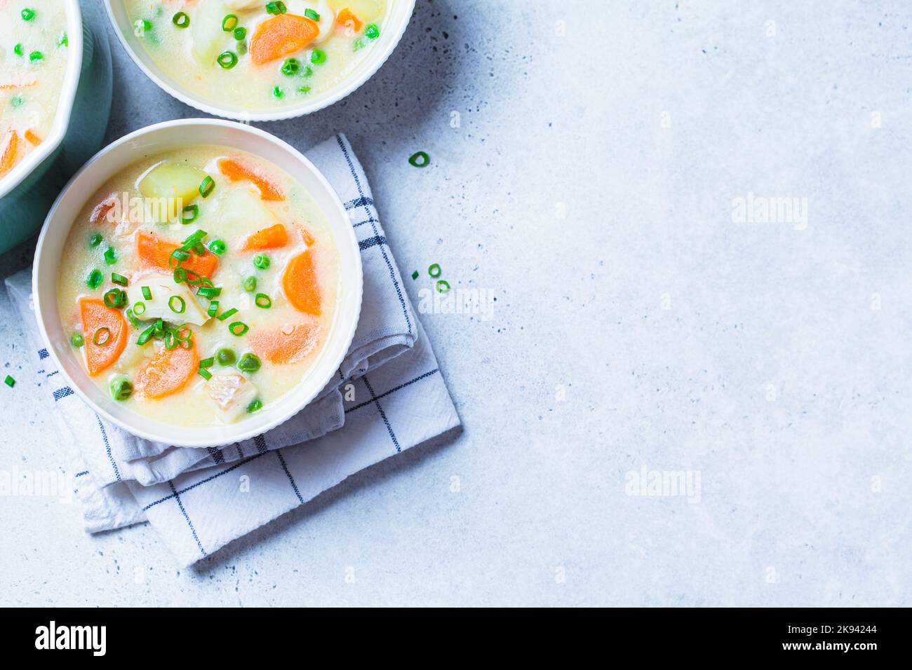 Fisch-Kabeljau-Chowder-Suppe mit grünen Erbsen, Kartoffeln und Karotten in einer weißen Schüssel, Draufsicht, Kopierraum. Stockfoto