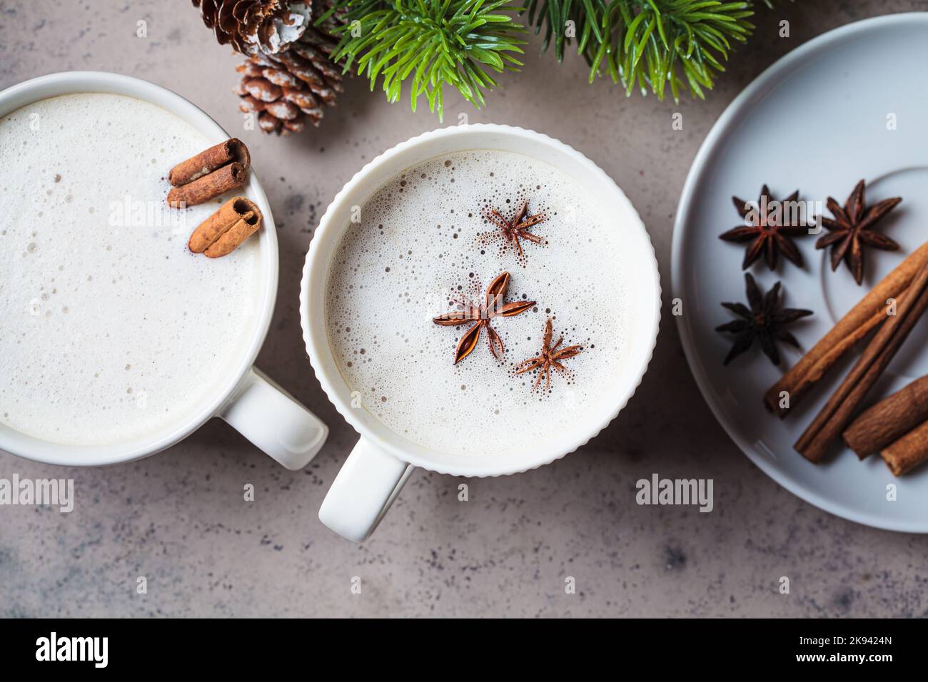 Hausgemachter Chai Latte mit Zimt und Sternanis in einer weißen Tasse, dunkler Hintergrund, Draufsicht. Weihnachtliche Hintergrund und Wintergetränk. Stockfoto