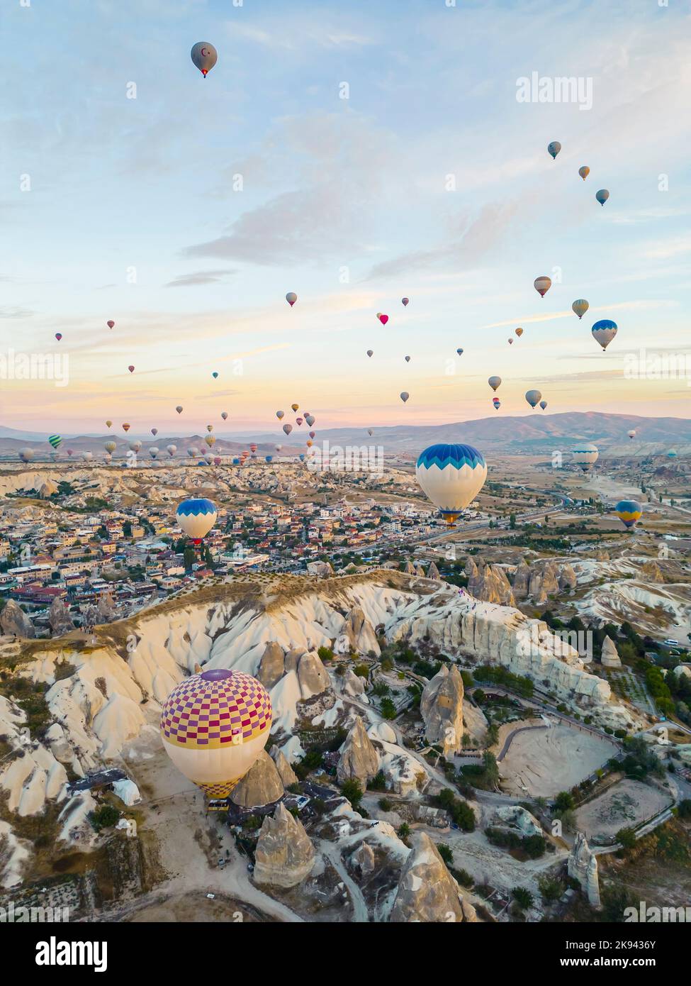 Wunderschöne Luftaufnahme von Dutzenden farbenfroher Luftballons, die über die felsige Landschaft von Kappadokien fliegen. Hochwertige Fotos Stockfoto