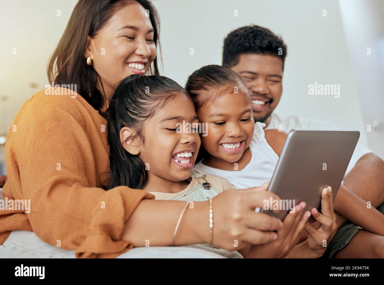 Digitale Tablet-Spiele für Kinder, Eltern und Familie, Filme herunterladen und online spielen in der Familie zu Hause. Glückliche Mädchen Kinder, Mama und Papa Stockfoto