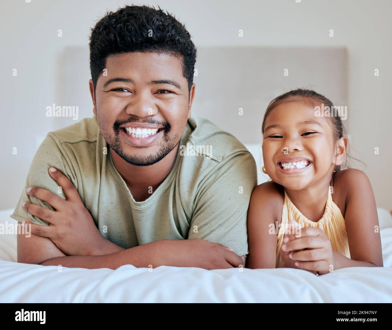 Asian, Vater und Mädchen im Bett, liegend und zusammen mit Lächeln, glücklich und Porträt im Schlafzimmer im Haus. Vater, Kind und Glück im Raum für Bindung und Stockfoto