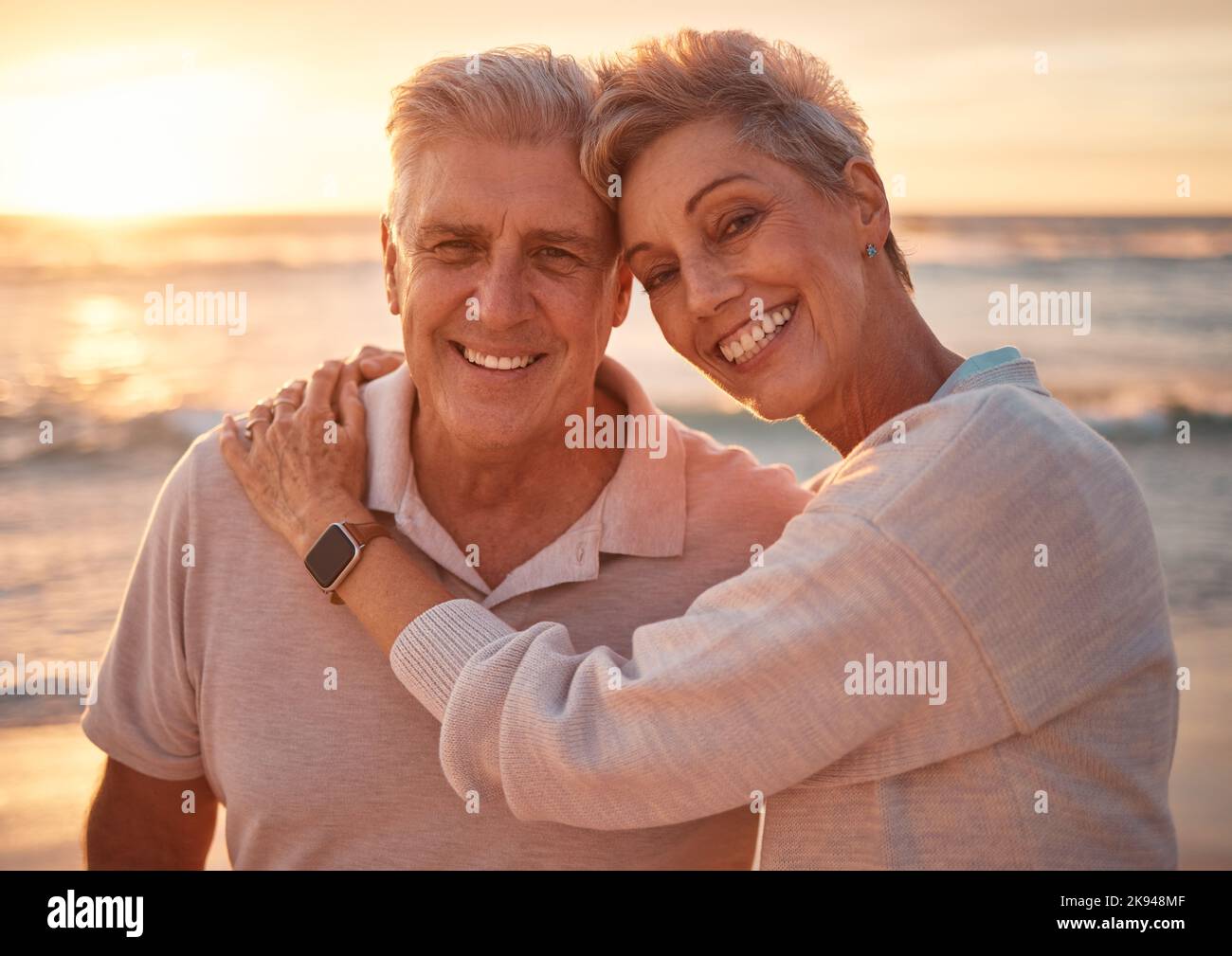 Seniorenpaar, Strandportrait und Umarmung im Urlaub, Reise oder Sommerurlaub. Liebe, Sonnenuntergang und ältere Menschen, Rentner und glücklicher Mann und Frau auf See oder Meer Stockfoto