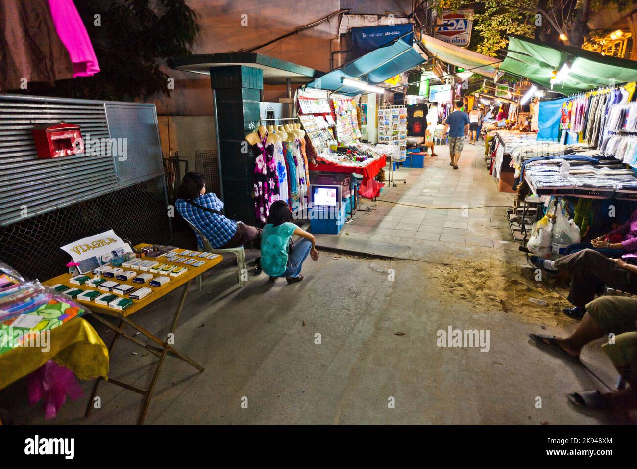 BANGKOK - 21. DEZEMBER: Marktmenschen sehen Fernsehen und bieten gefälschte Medikamente wie VIAGRA auf dem Straßenmarkt in Sukhumvit Road am 21. Dezember 2009 in Bangkok an, Stockfoto