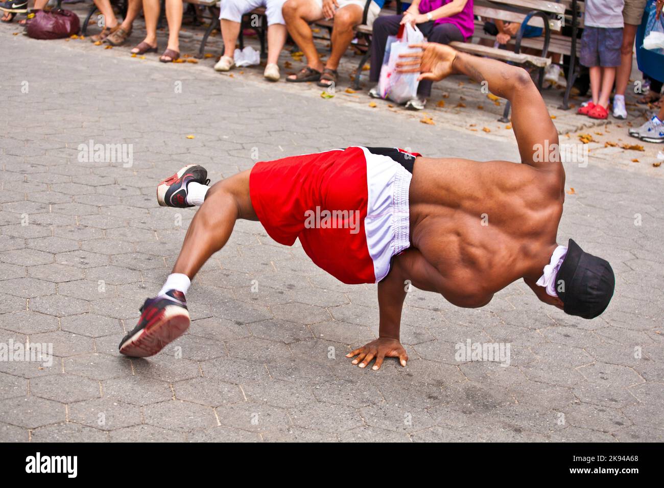 New York, USA - 9. Juli 2010: Bremstänzerin bei einer Open-Air-Performance für Touristen im Battery Park in New York City. Sie bitten um eine Spende, um Mo zu verdienen Stockfoto