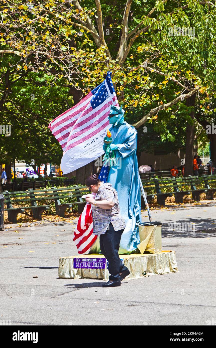 New York, USA - 9. Juli 2010: Straßenperformance im Battery Park in New York City. Mann, der als Freiheitsstatue mit Pantomime gekleidet ist, bittet um Spende. Stockfoto