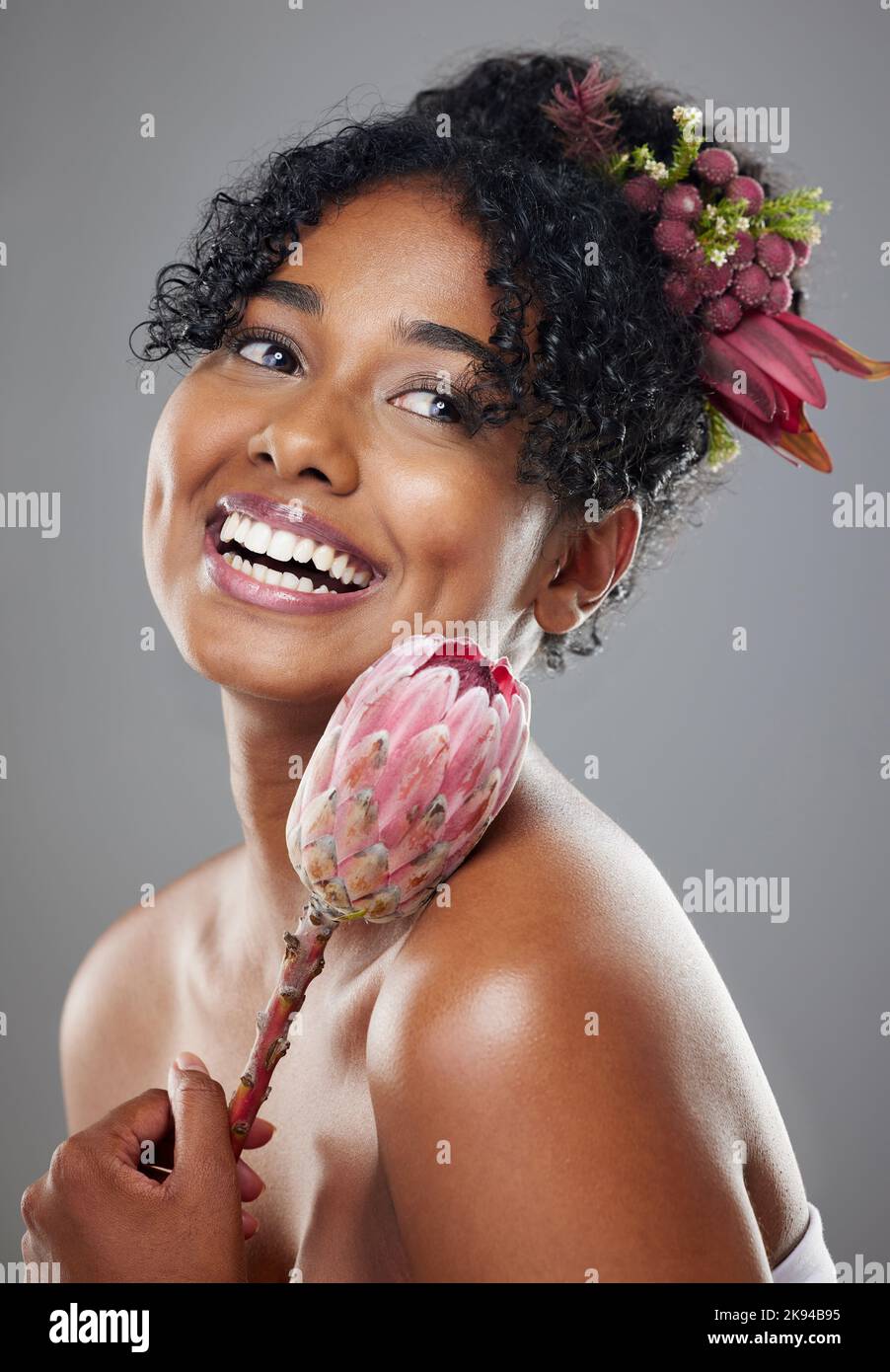 Protea-Blumen, glückliche Frau und natürliche Schönheit, leuchtende Hautpflege und Bio-Öko-Make-up, ästhetisches Wellness oder florales Parfüm auf Studiohintergrund Stockfoto