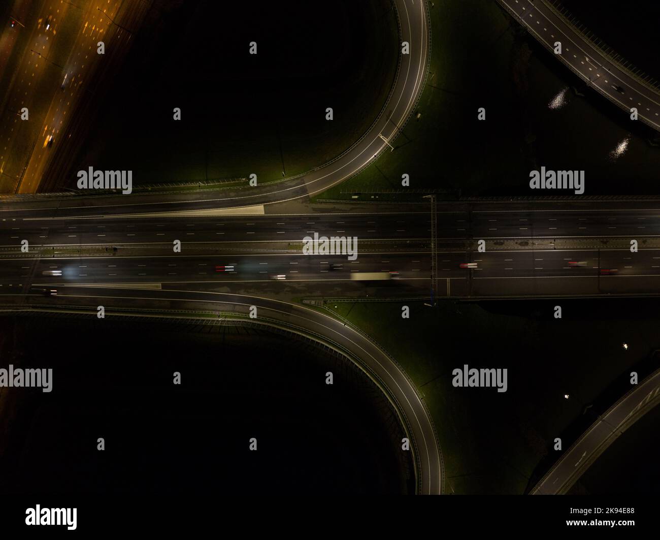 A10 Straßenverkehr in der Nacht. Autobahninfrastruktur im Dunkeln Licht des dynamischen, sich bewegenden Verkehrs auf der Straße bei Amsterdam IJburg in den Niederlanden Stockfoto