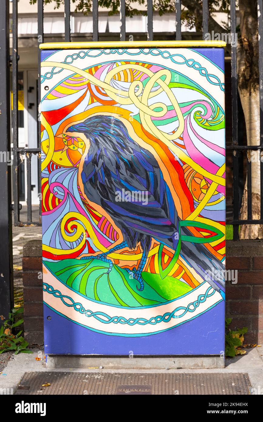 Irland Irland Irland Irland Straßenkunst in Dublin Moderne zeitgenössische Art-Deco-Malerei eines schwarzen Vogels farbenfroher Hintergrund auf einem Bürgersteig aus Metall-Anschlusskasten Stockfoto