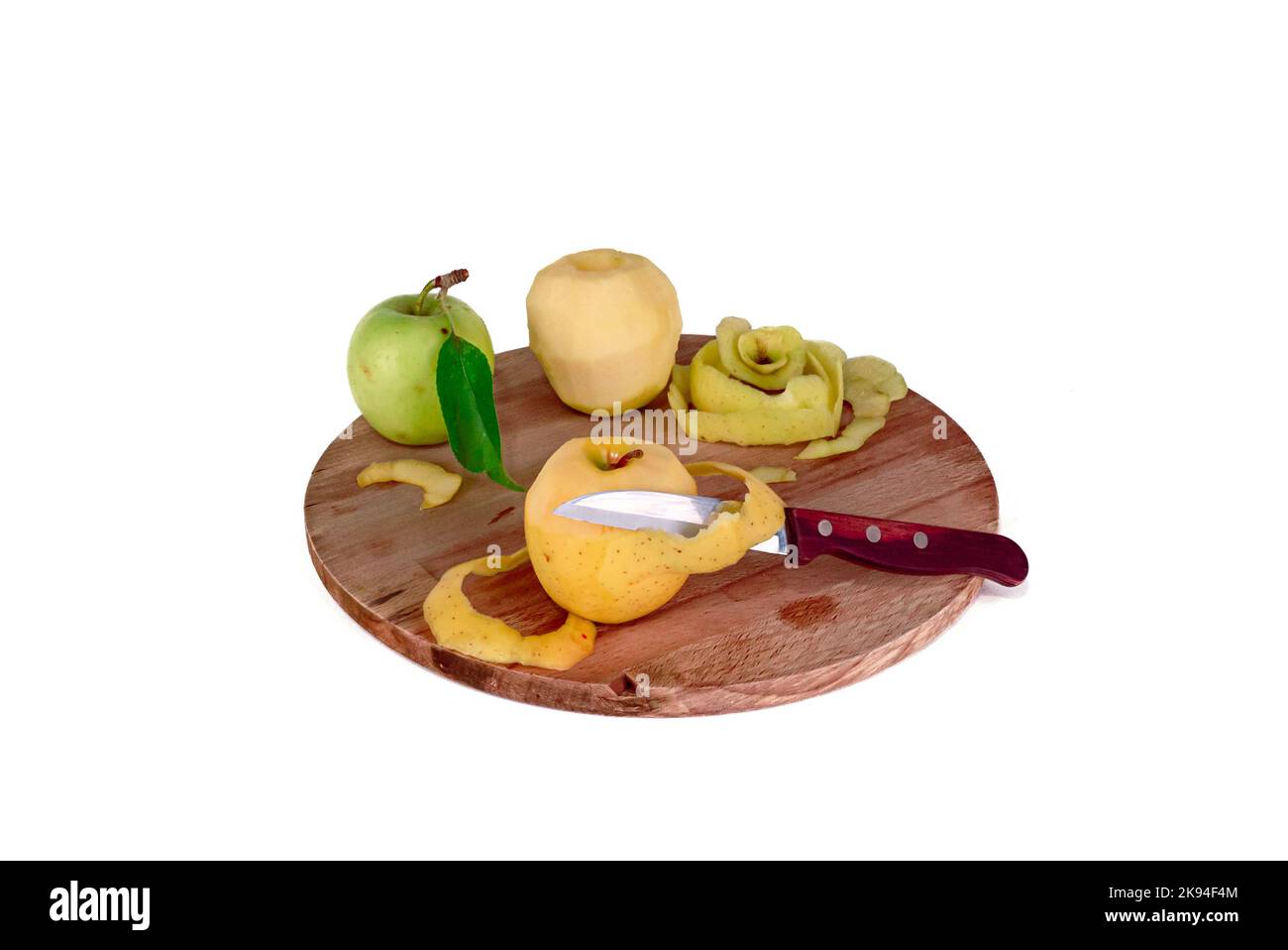 Gelbe Apfelscheiben auf einem hölzernen Schneidebrett geschnitten. Äpfel, die mit einem Spaltmesser oder einem halbgoldenen Schneidemesser geschnitten werden, köstlich in Scheiben geschnittenes, grünes Blatt. Selektive Stockfoto