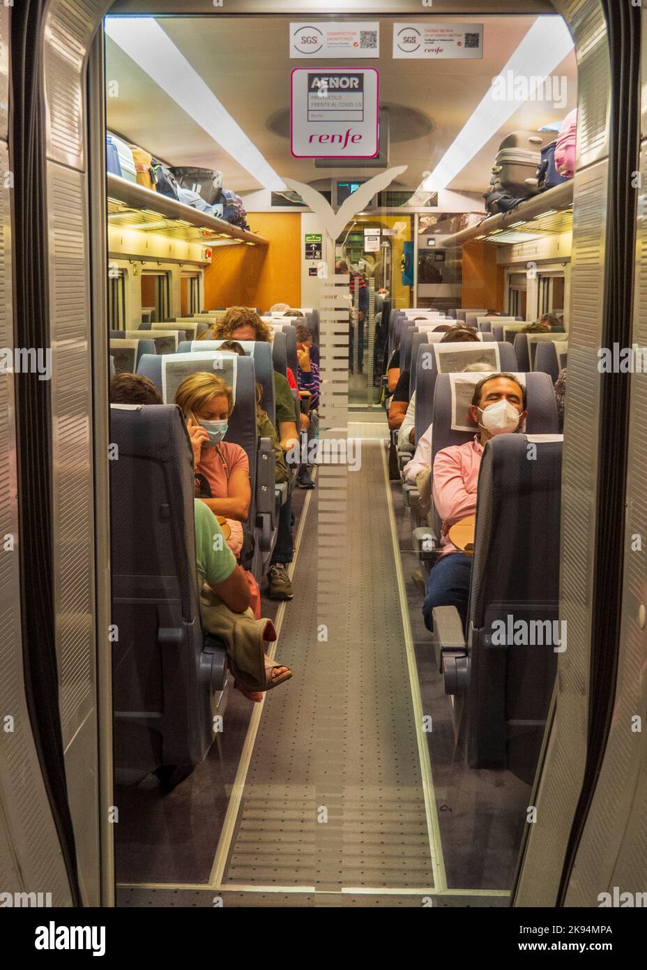 Blick auf einen Eisenbahnwagen mit Passagieren, die auf ihren Sitzen am Bahnhof Atocha in Madrid sitzen. Stockfoto