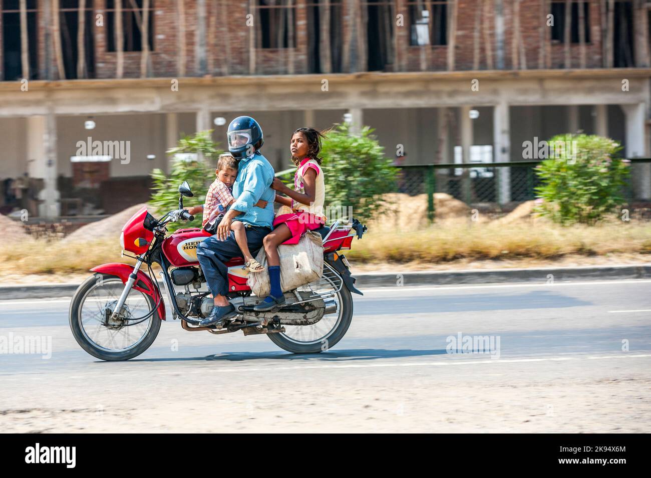 RAJASTHAN - INDIEN - OKTOBER 17: Vater mit zwei Kindern auf Roller durch geschäftige Autobahn Straße am 17. Oktober 2012 in Rajasthan, Indien. Bis zu sechs fam Stockfoto