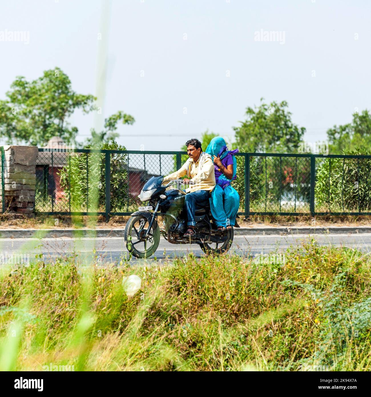 RAJASTHAN - INDIEN - OKTOBER 17: Paar fährt am 17. Oktober 2012 in Rajasthan, Indien, mit dem Roller durch eine verkehrsreiche Straße auf der Autobahn. Bis zu sechs Familienmitglieder Stockfoto