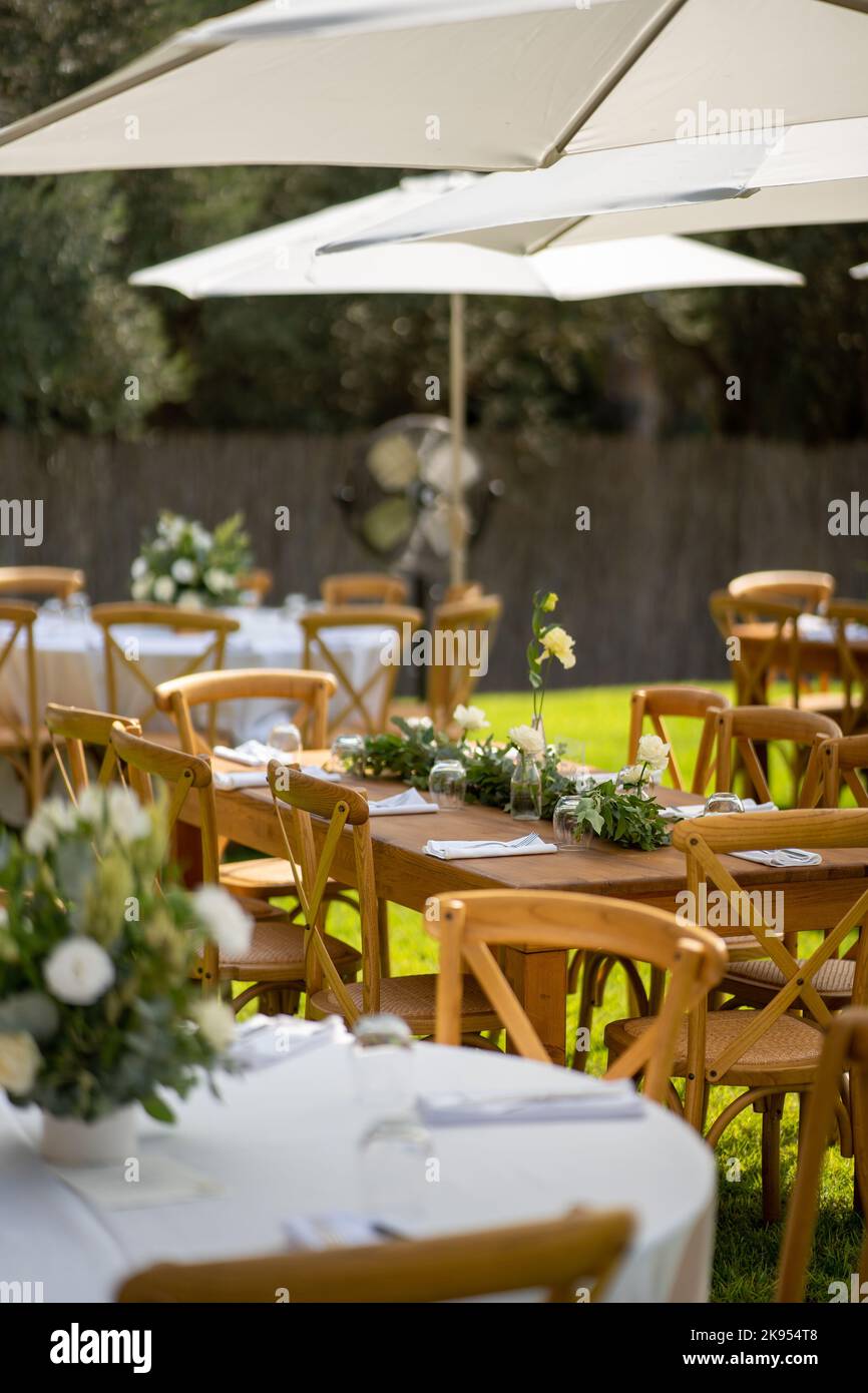 Eine vertikale Aufnahme von Stühlen und Tischen in einem Restaurant im Freien Stockfoto