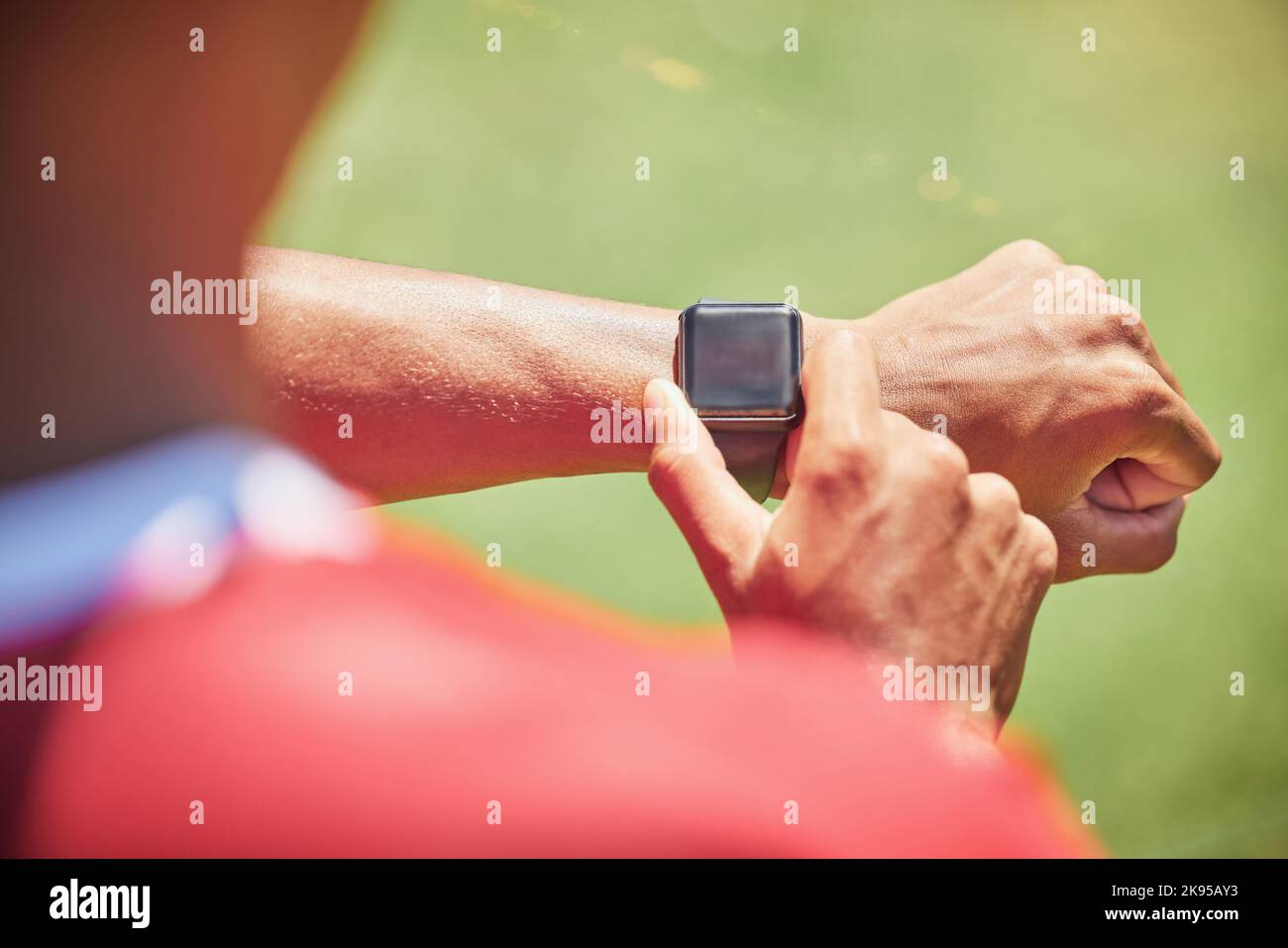 Smartwatch, Screen-Mock-Up und Fitness-Hands-Mann überprüfen die Laufergebnisse, den Fortschritt des Sport- oder Trainingsfortschritts auf dem grünen Spielfeld. Athlet on Stockfoto